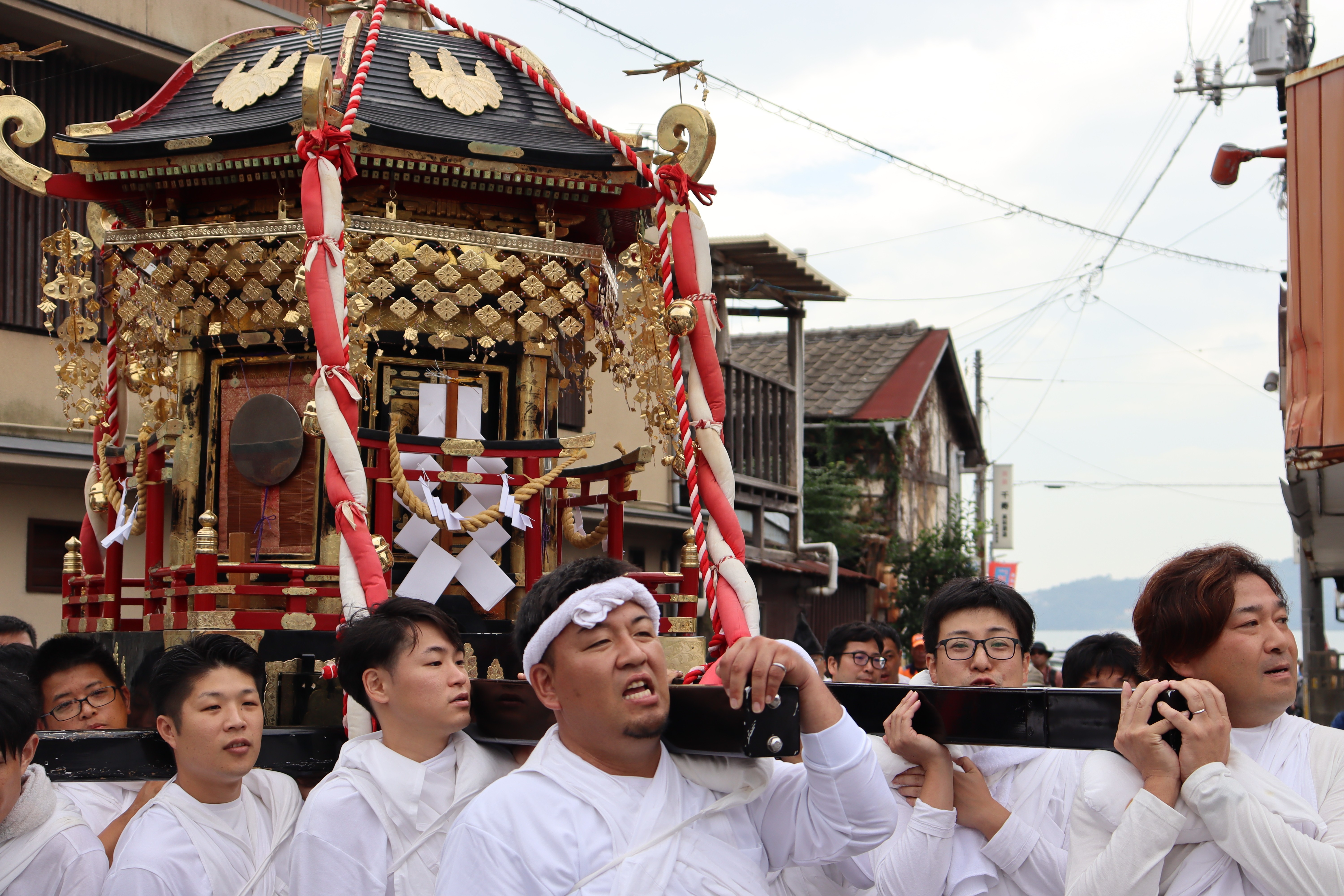 Group of Japanese men lifting and parading the neighborhood with a large 'danjiri' float