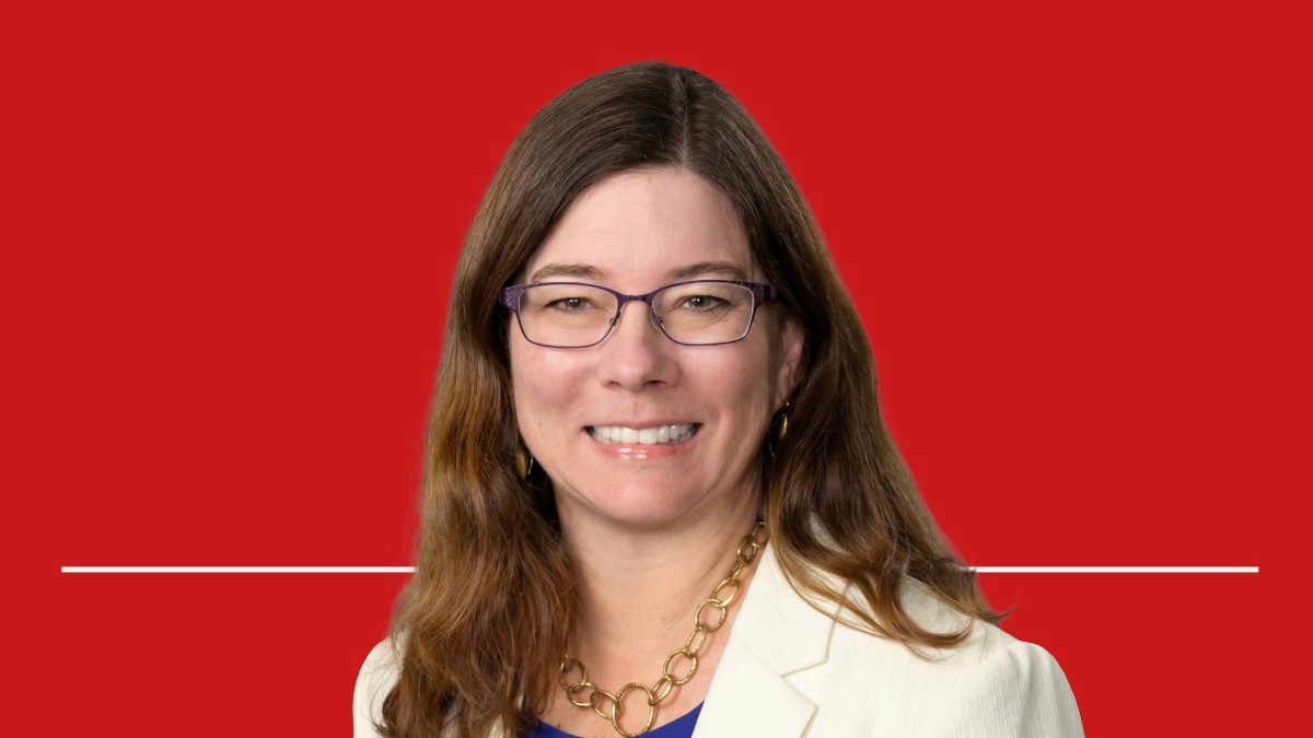 Image of Dr. Shannon Udovic-Constant, Value Health Voices podcast guest, against a red backdrop