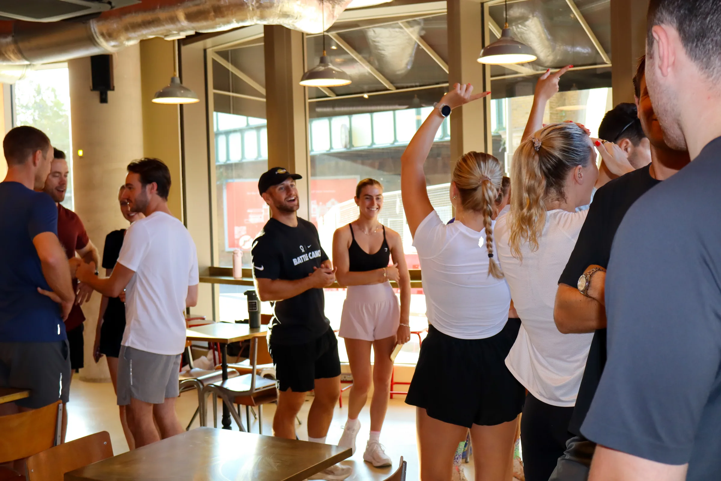 A group in workout clothes chatting and laughing in a café