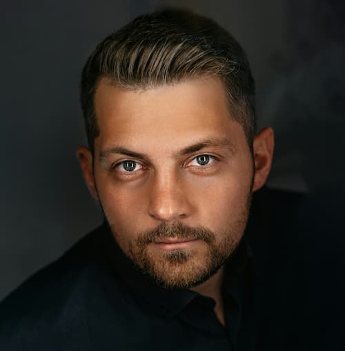Man wearing black suit staring at the camera