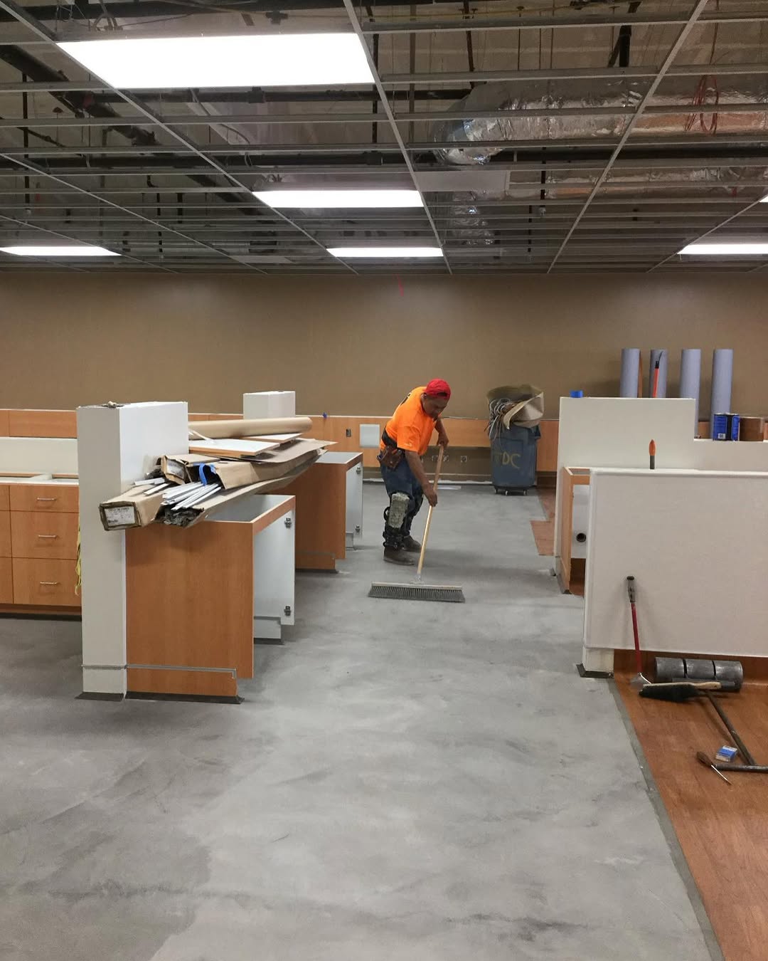 Installer prepping the floor as the first sheet vinyl goes down