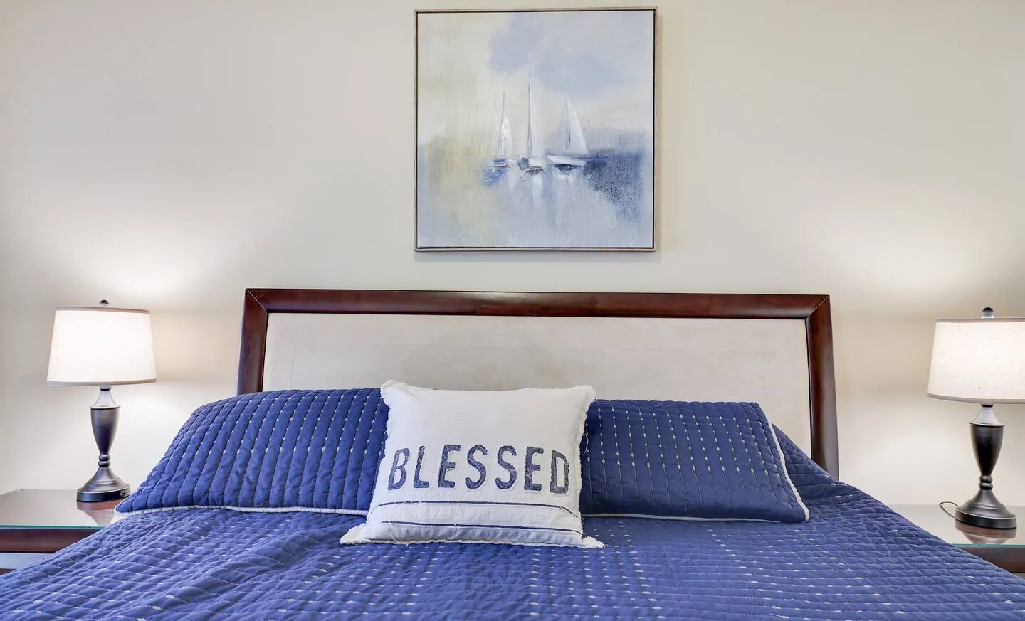 King bed with navy quilt and upholstered headboard at Mountainwoods Memories