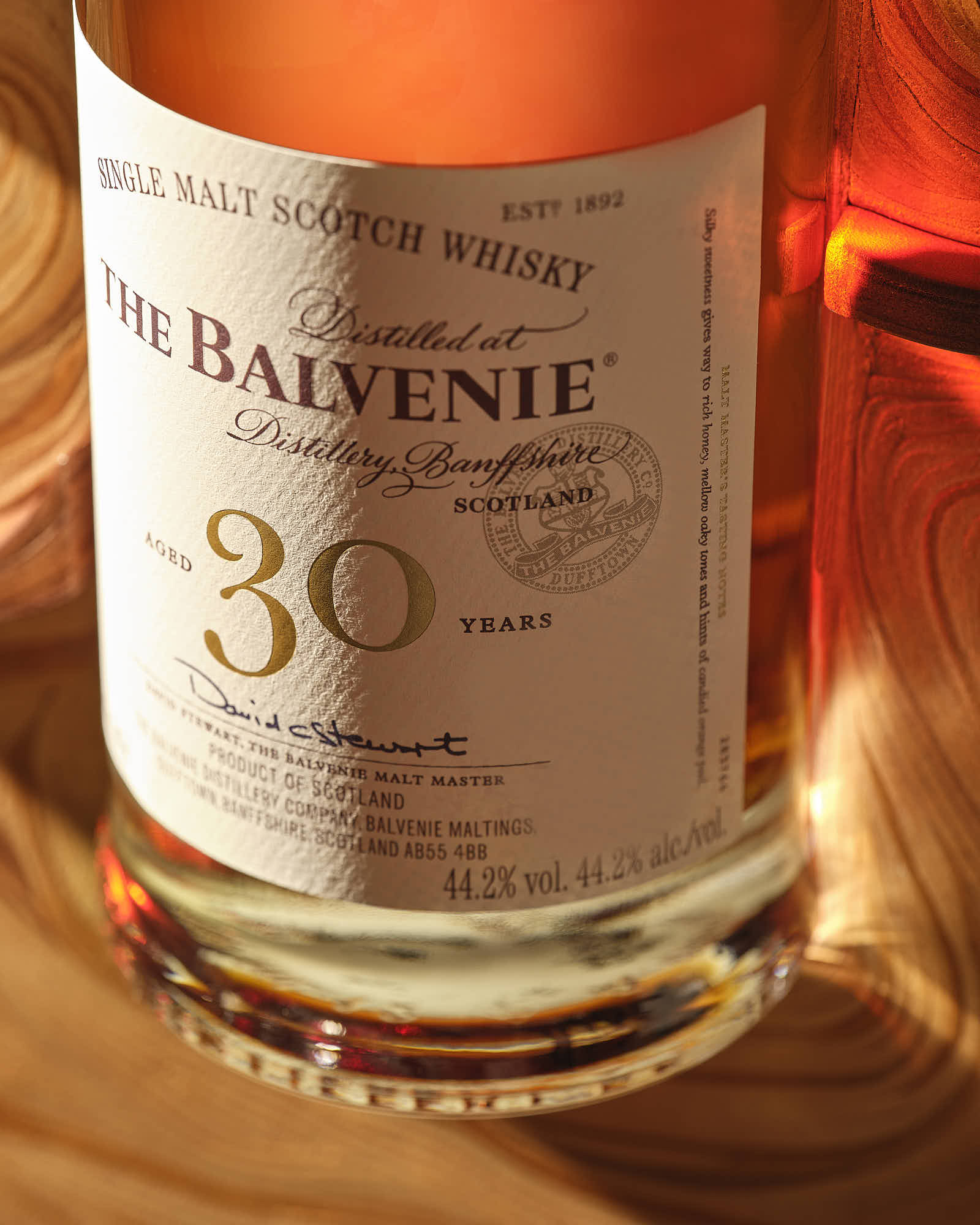 Close-up of a bottle label, featuring an elegant design with a light-colored liquid inside.