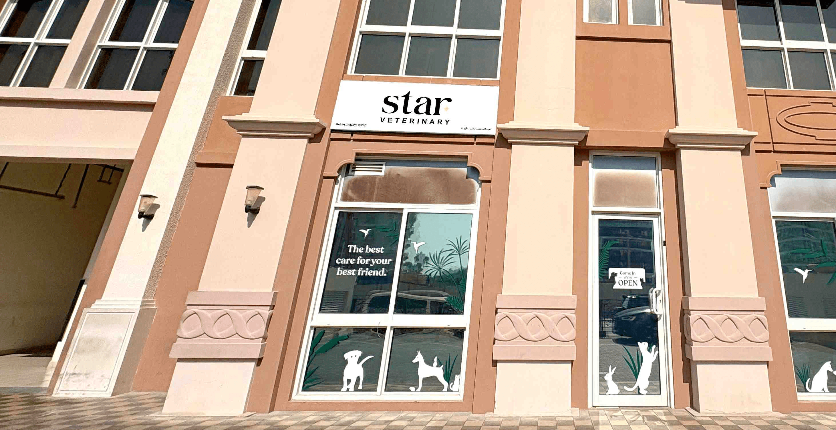 The front of Noble Veterinary Clinic in DIP, Dubai. Our vet clinic features glass doors and windows with reverse silhouettes of pets on the windows surrounding the doors.