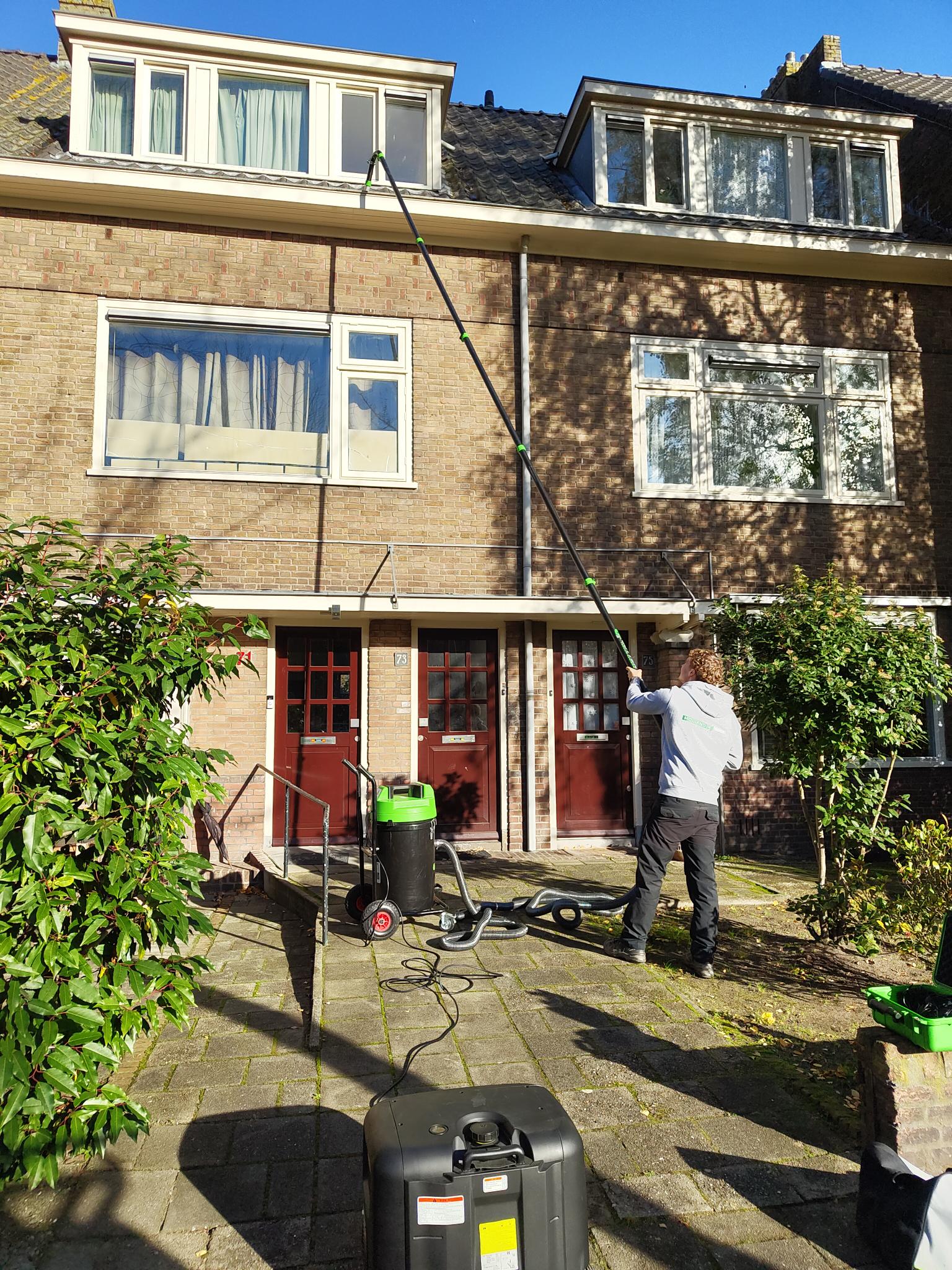 Schoonmaken van dakgoot met stofzuiger