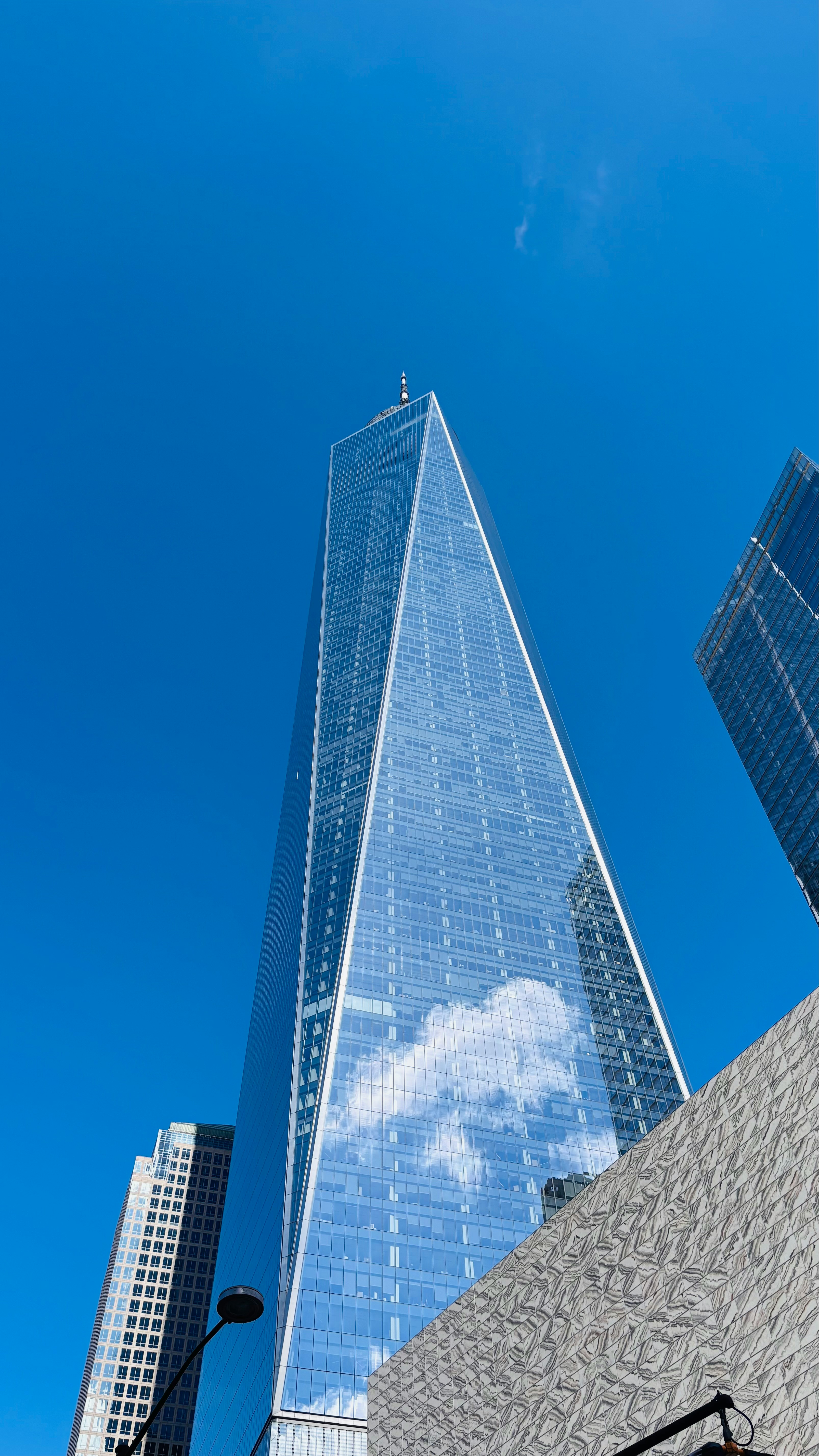 Modern glass skyscraper reflecting blue sky and clouds