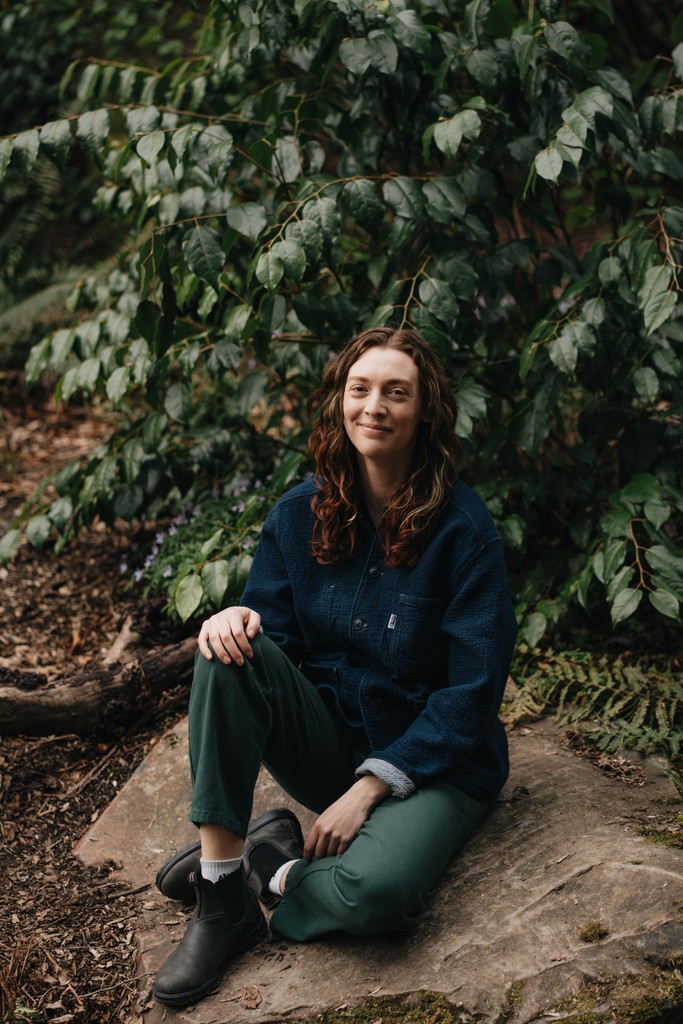 Amy smiling infront of a waterfall in the forest