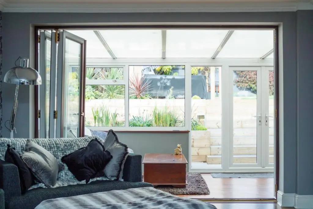 A cozy living room features a modern couch and large glass doors leading to a bright outdoor space.