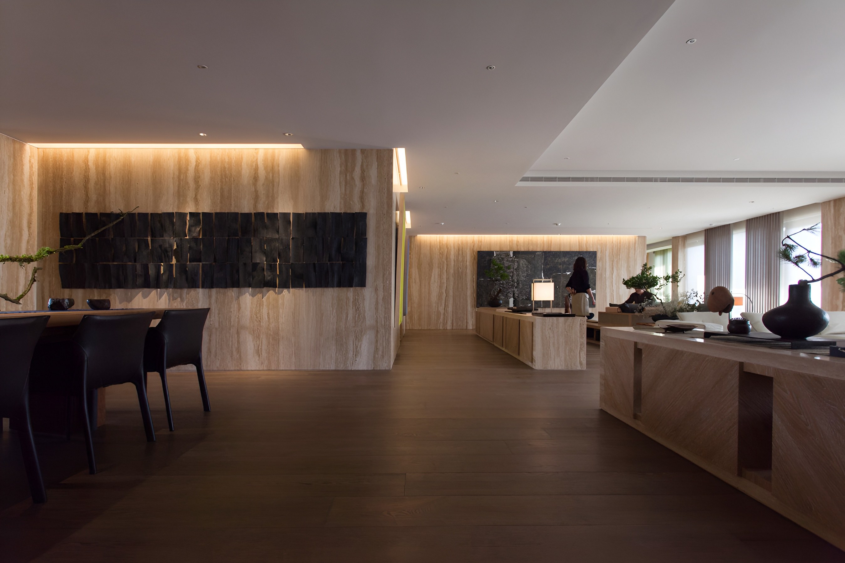 開放式空間融合用餐區與客廳，木質元素與暗色藝術牆飾提升整體建築質感