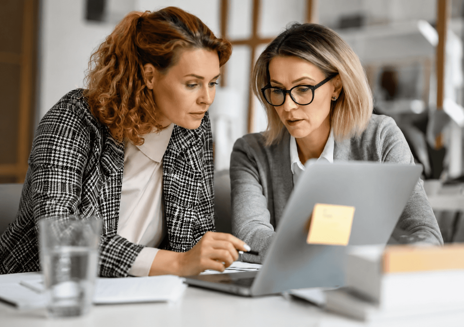 Two business professionals collaborating at a laptop while discussing affiliate partnerships.