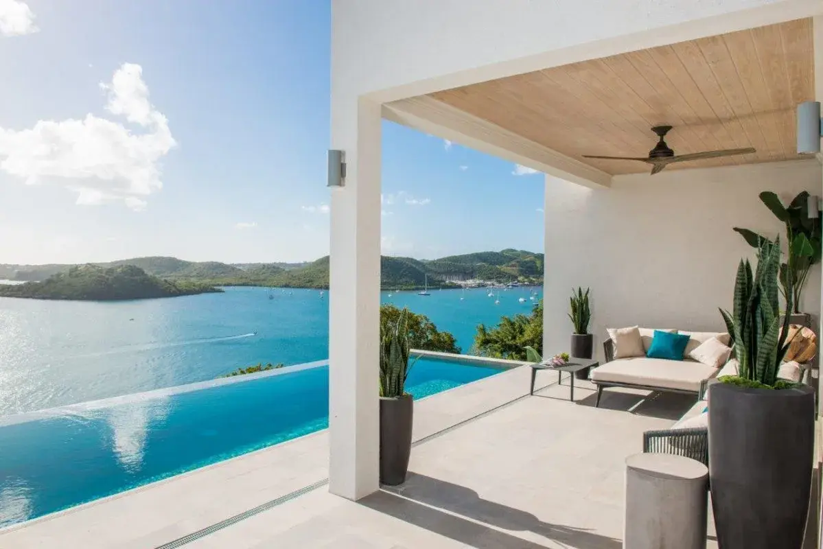 Covered terrace with infinity pool and panoramic Caribbean sea views at Calivigny Point resort in Grenada