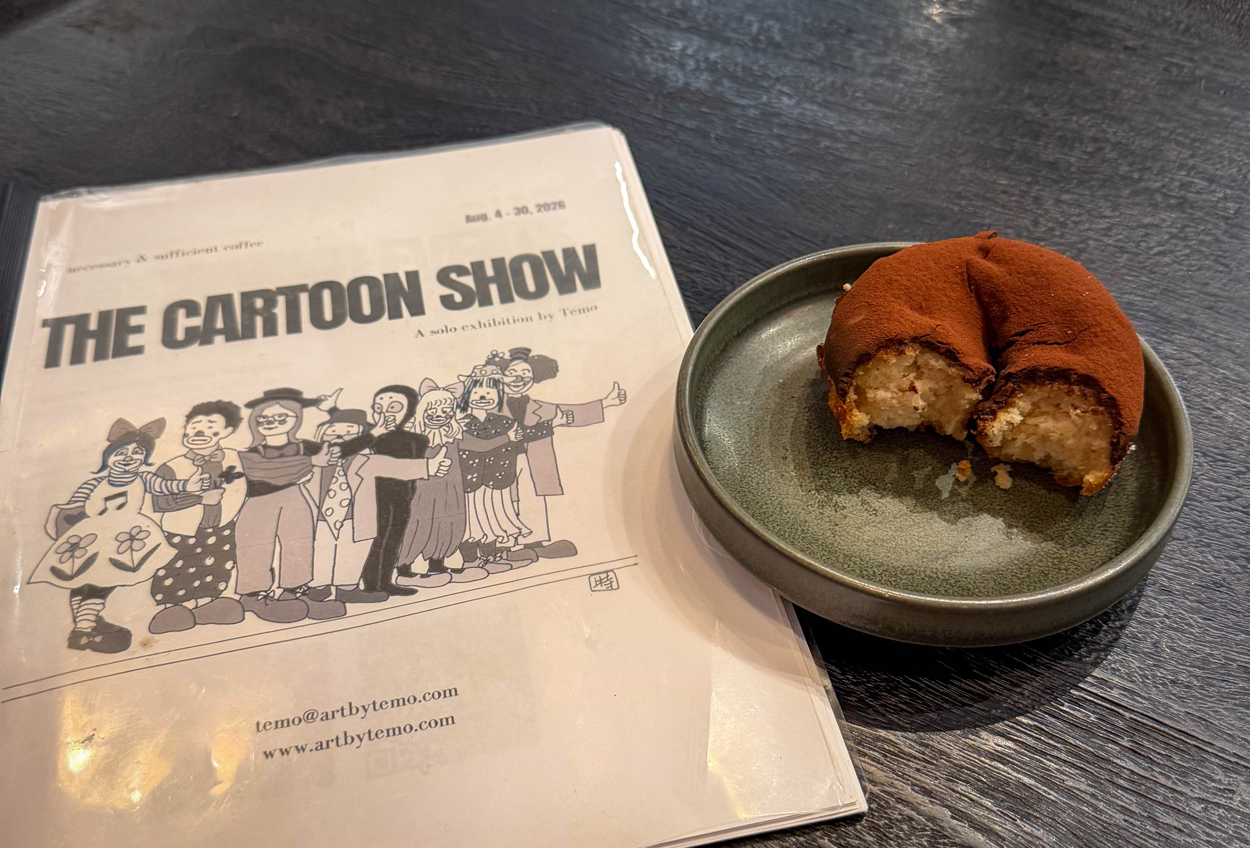 a donut with bites out of it sitting next to a cartoon show zine