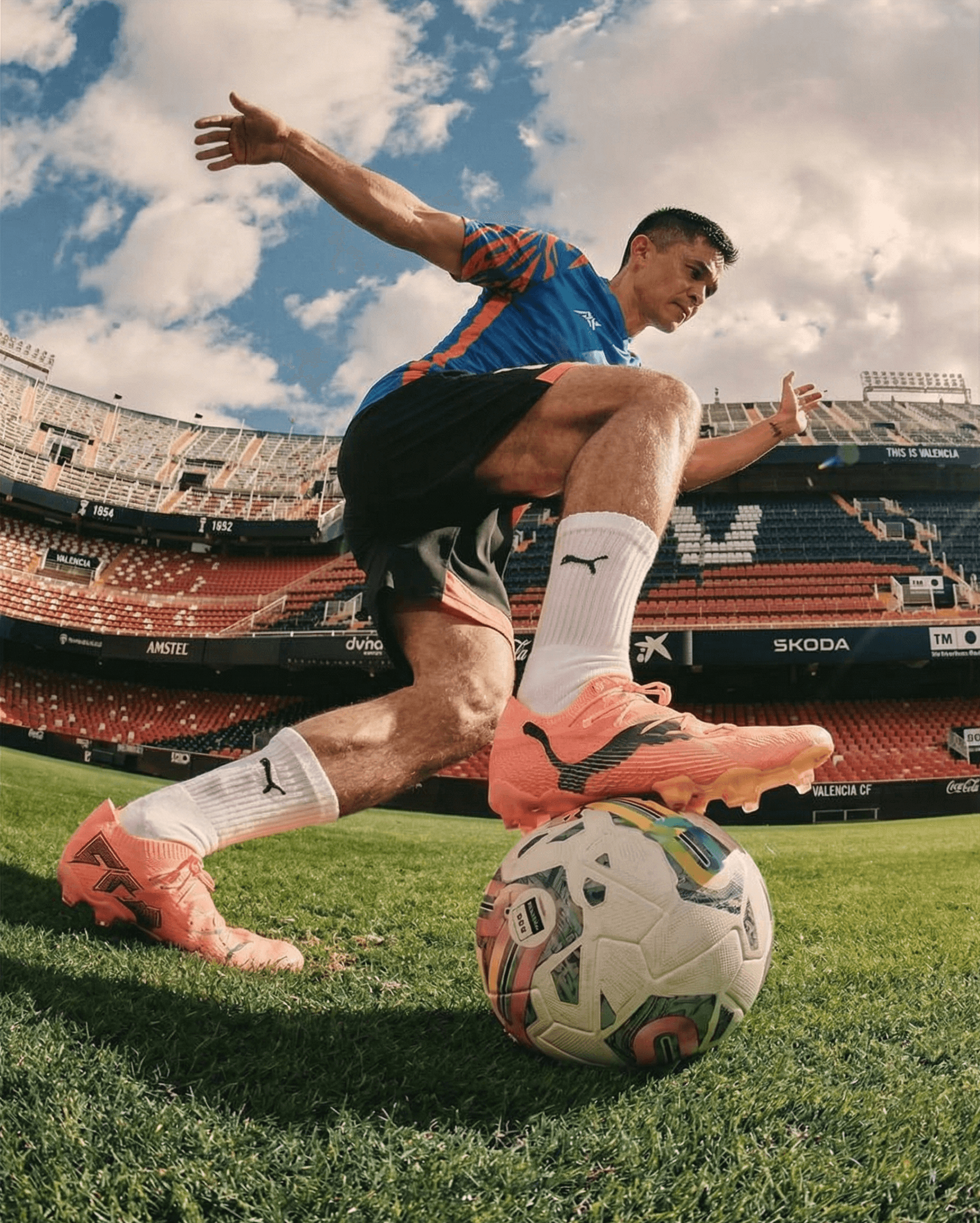 Soccer player controlling ball with foot on grass field inside stadium