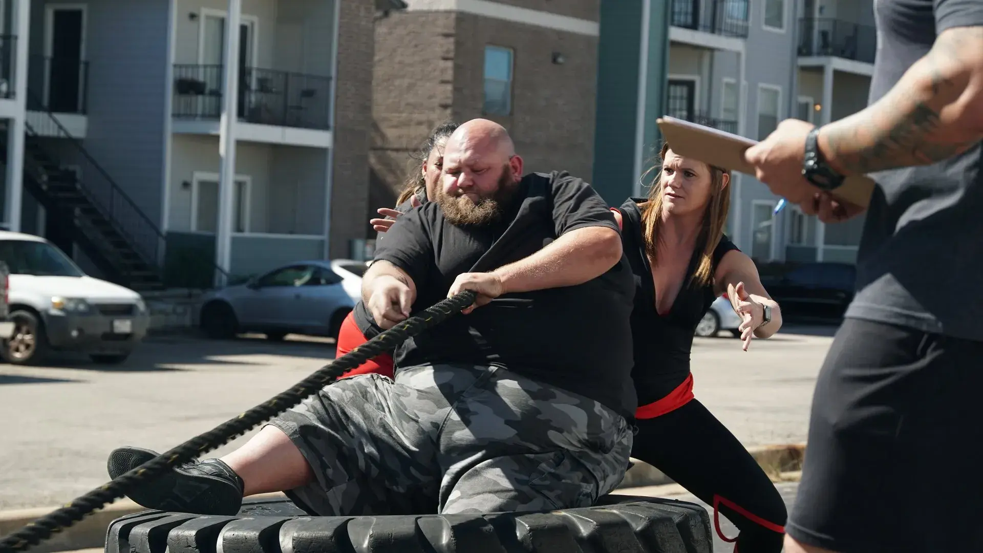 Athlete performing arm over arm tire pull during a strongman event