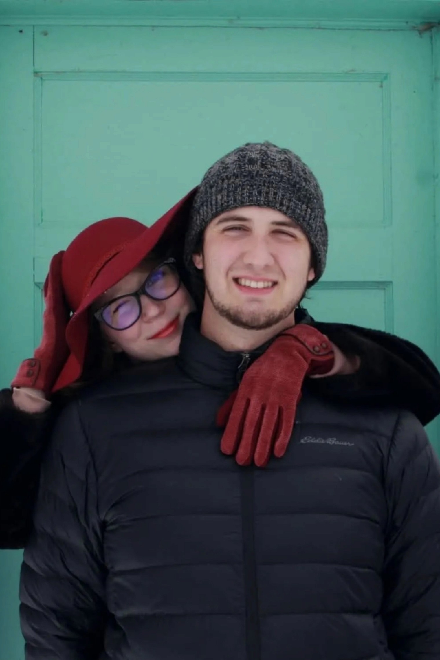 A bride in a white lace wedding dress holds a colorful bouquet of pink, yellow, and orange flowers.