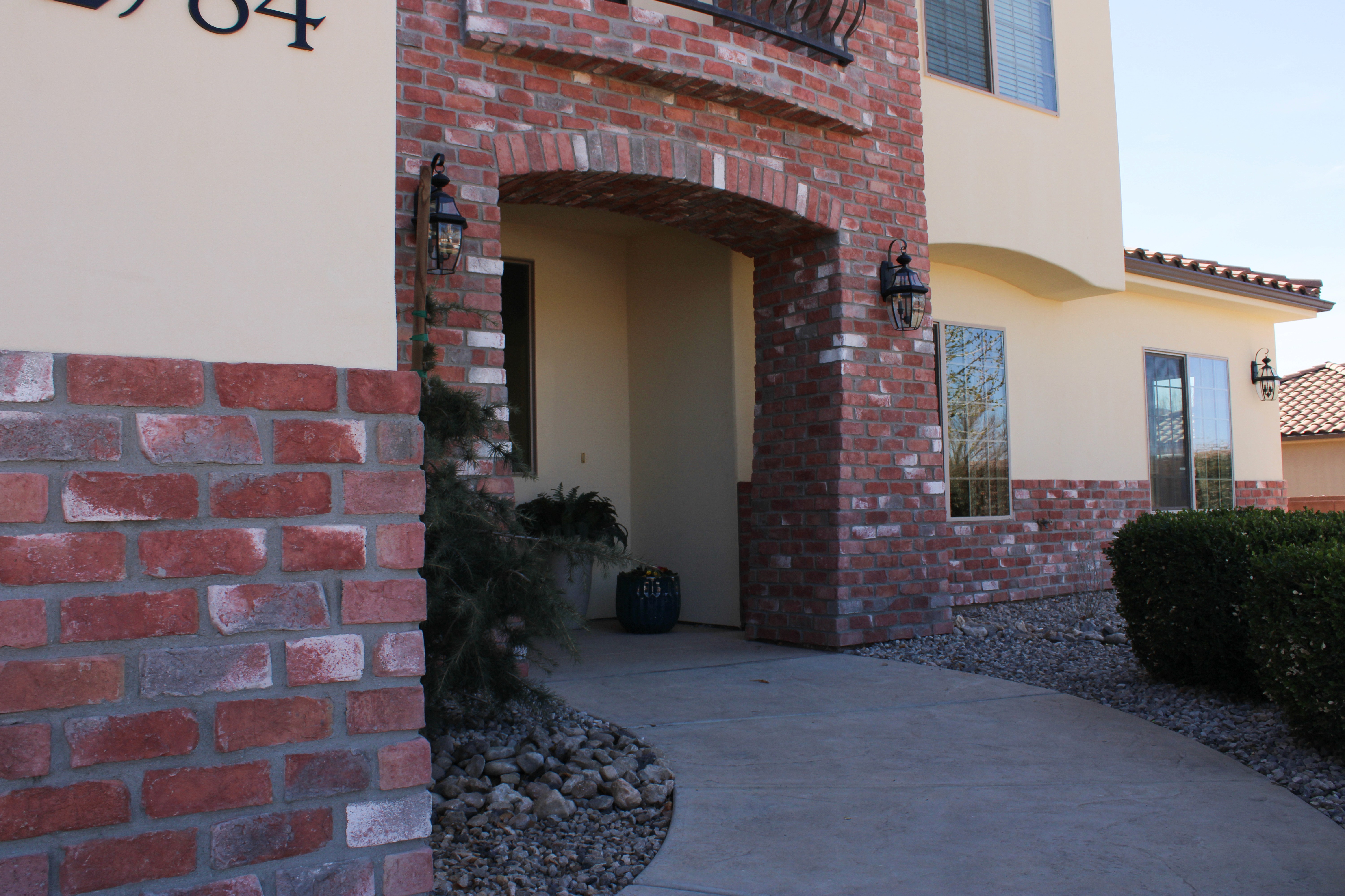Side view of a custom home in Southern Utah with red brick, stucco walls, and modern architectural details