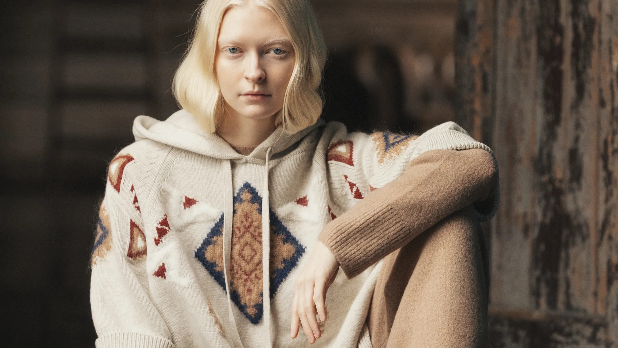 Model wearing ivory cashmere hoodie with geometric intarsia pattern and beige knit pants – Annapurna