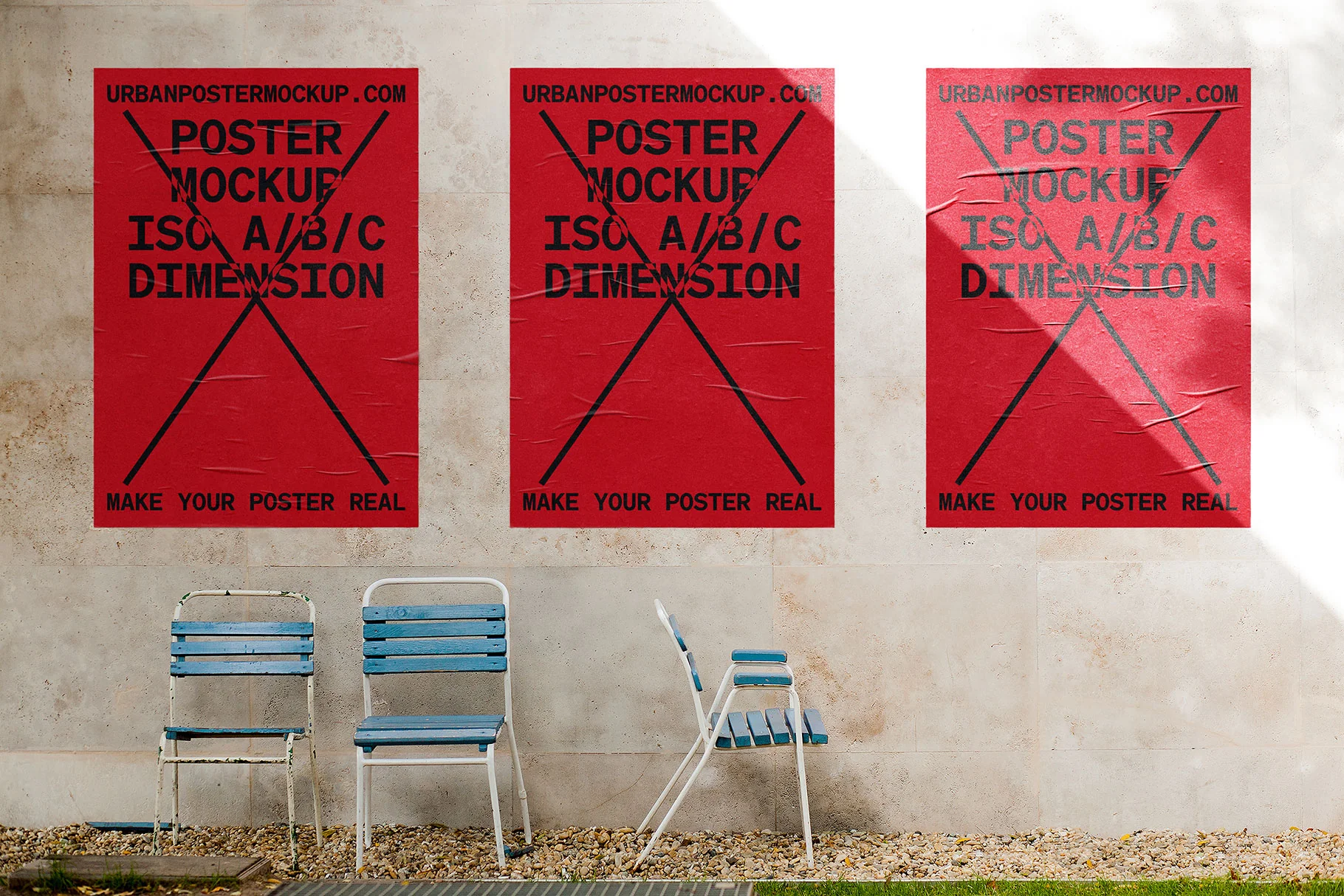 Three red posters with black graphic elements and text are displayed on a textured concrete wall. Below the posters, vintage blue and white metal chairs sit on a gravel surface, creating an urban outdoor setting.