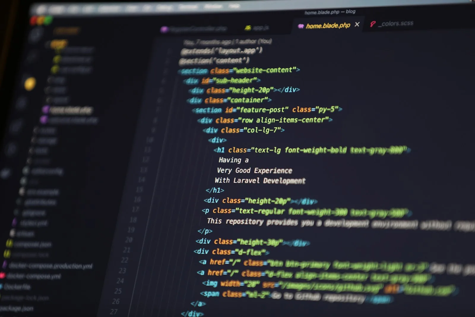Developer comparing website builder interfaces on a laptop screen showing code and a visual design canvas side by side