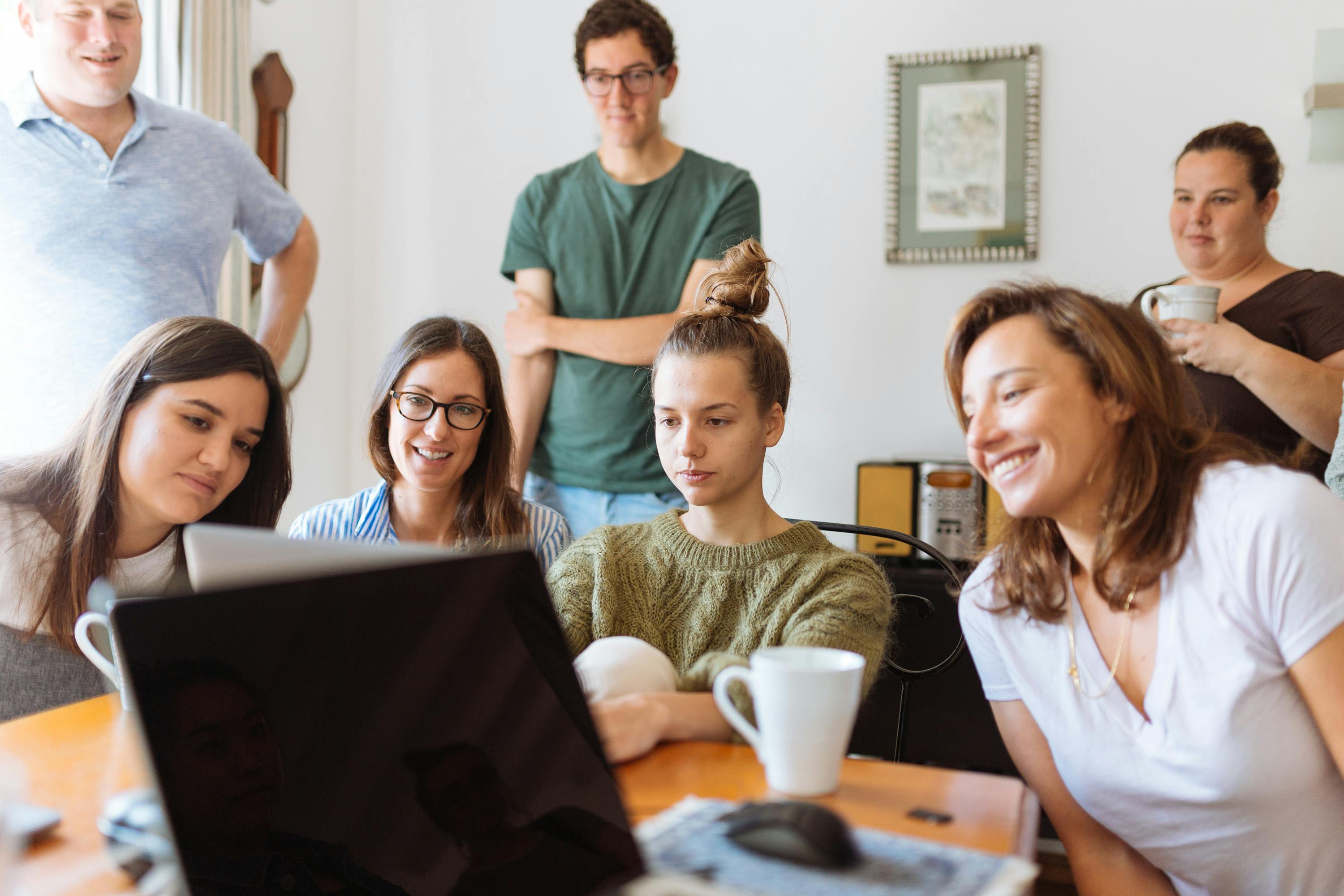 a group of people looking at a laptop