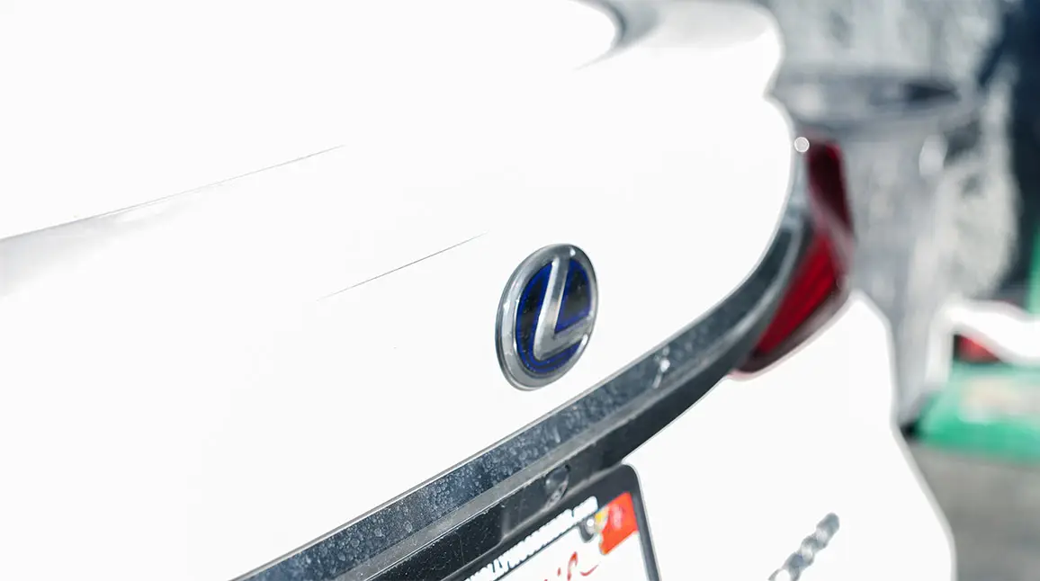 Close-up of Lexus emblem highlighting attention to detail in auto body repair.