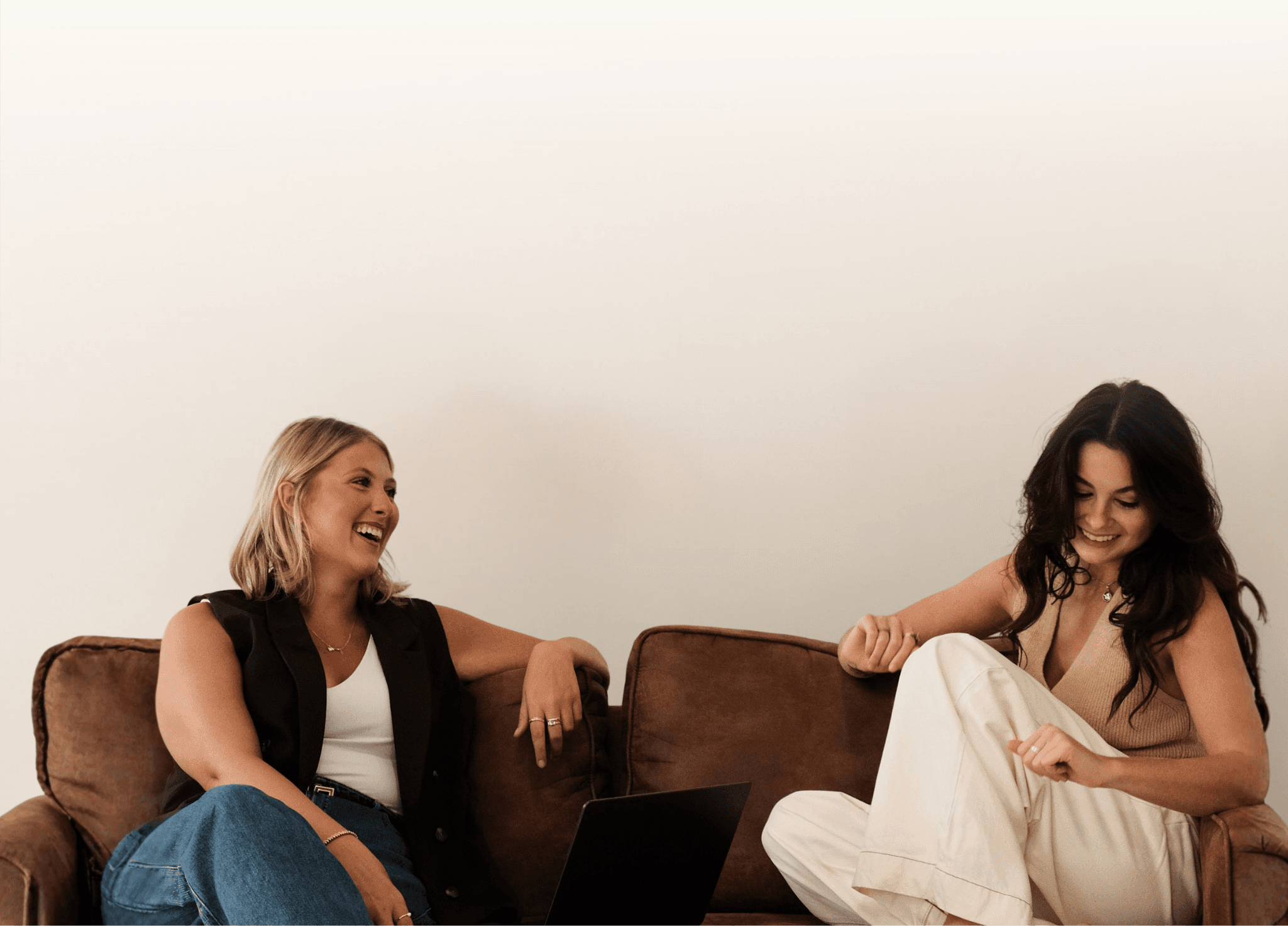 Common Thread Co. founders Fallon and Molly sitting together, celebrating because they get to help a small business owner own their thread
