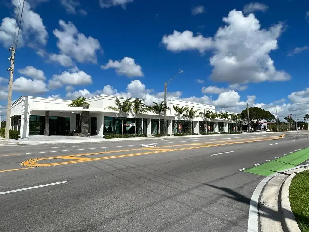 SPSA Retail Center corner view showing the curved entrance and full storefront facade under blue sky