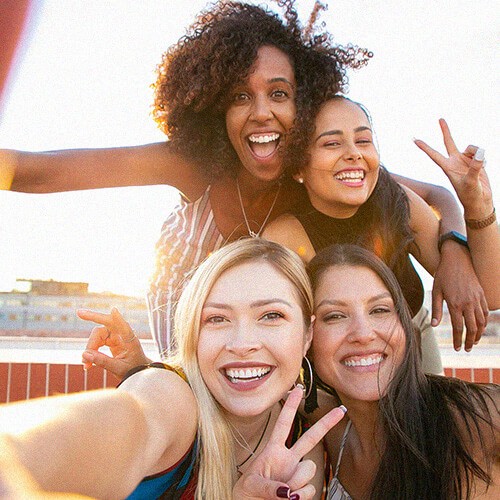 Grupo de amigas Gen Z haciéndose una selfie al aire libre