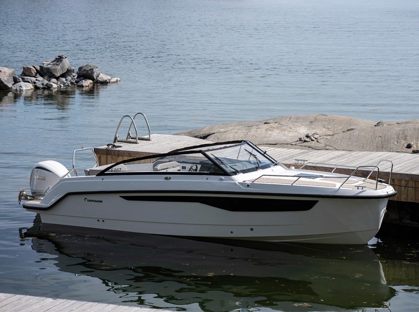 A boat Yamarin 80 DC docked to a wooden pier by the rocks