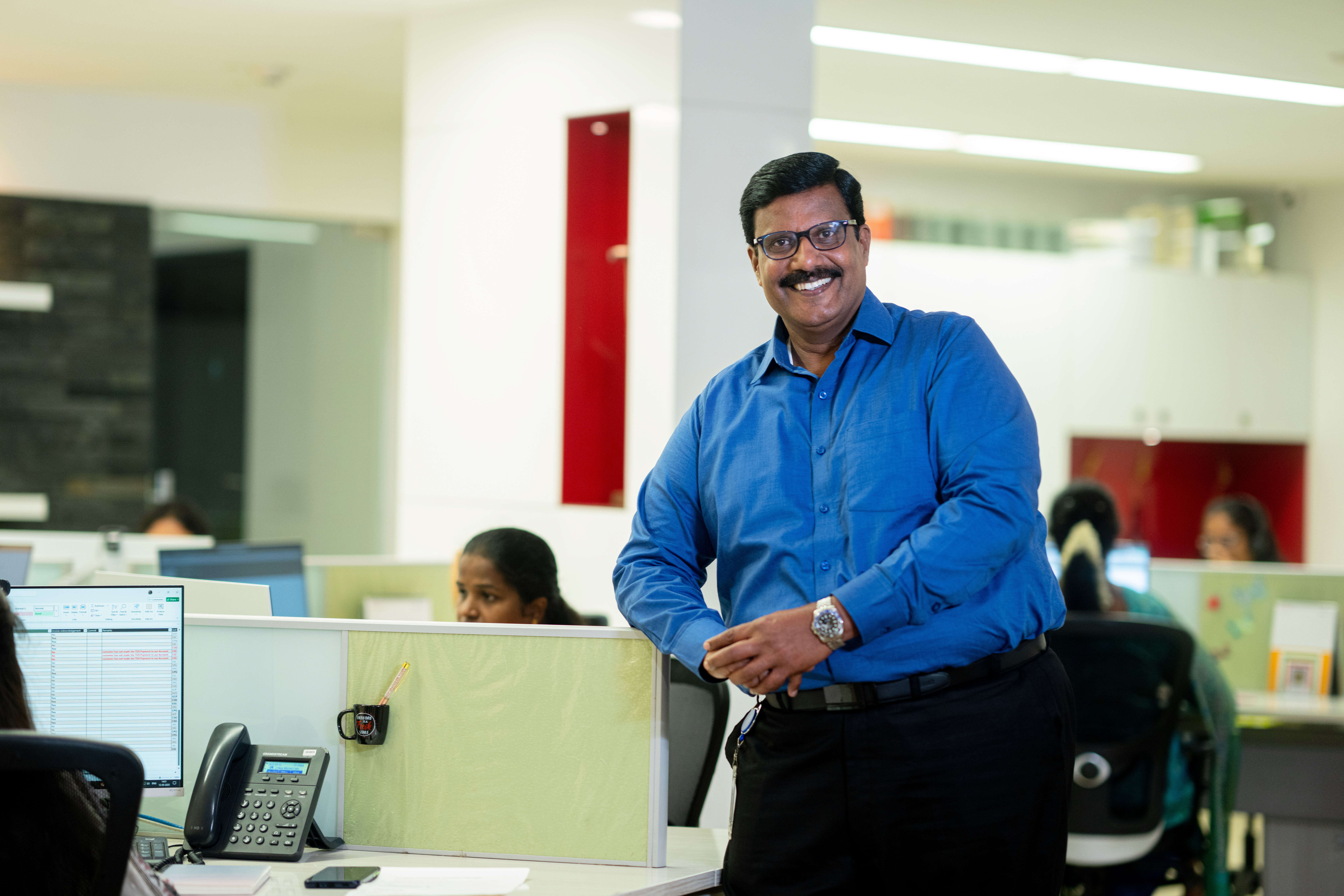a group of people sitting at a table with computers
