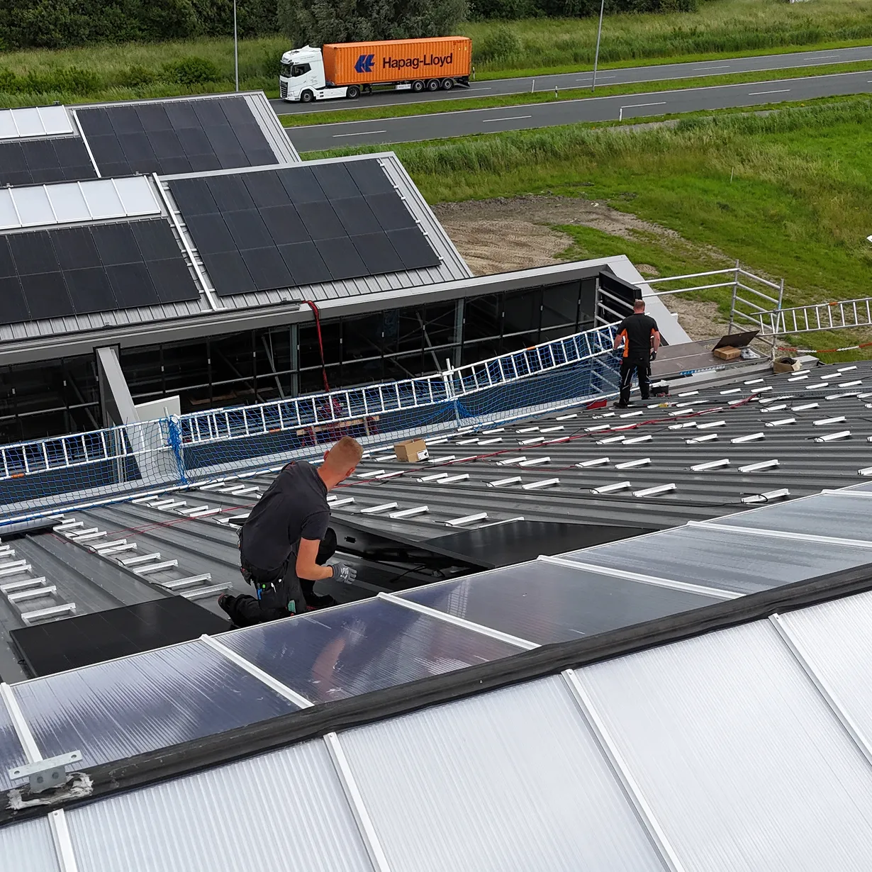 Monteur bei der Installation einer PV-Anlage auf dem Dach eines Gartencenters