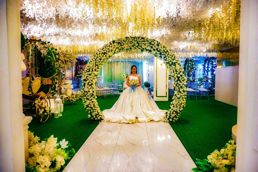 Bride beneath the grand floral arch of Celestia Hall, Stalla Suites QC