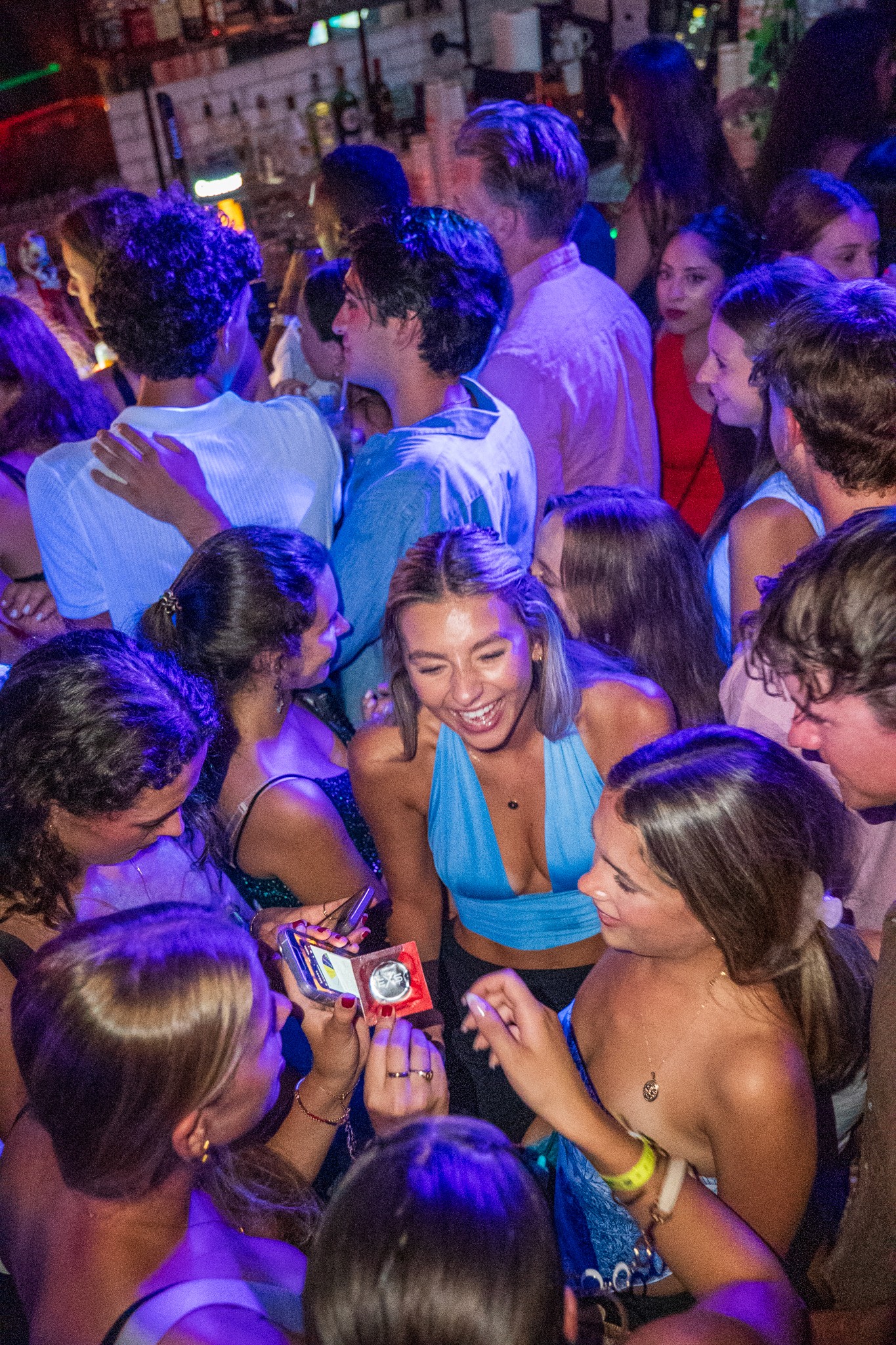 Young international travelers socializing and laughing together during a pub crawl in Nice inside a lively bar showcasing the typical age group and social atmosphere of French Riviera nightlife