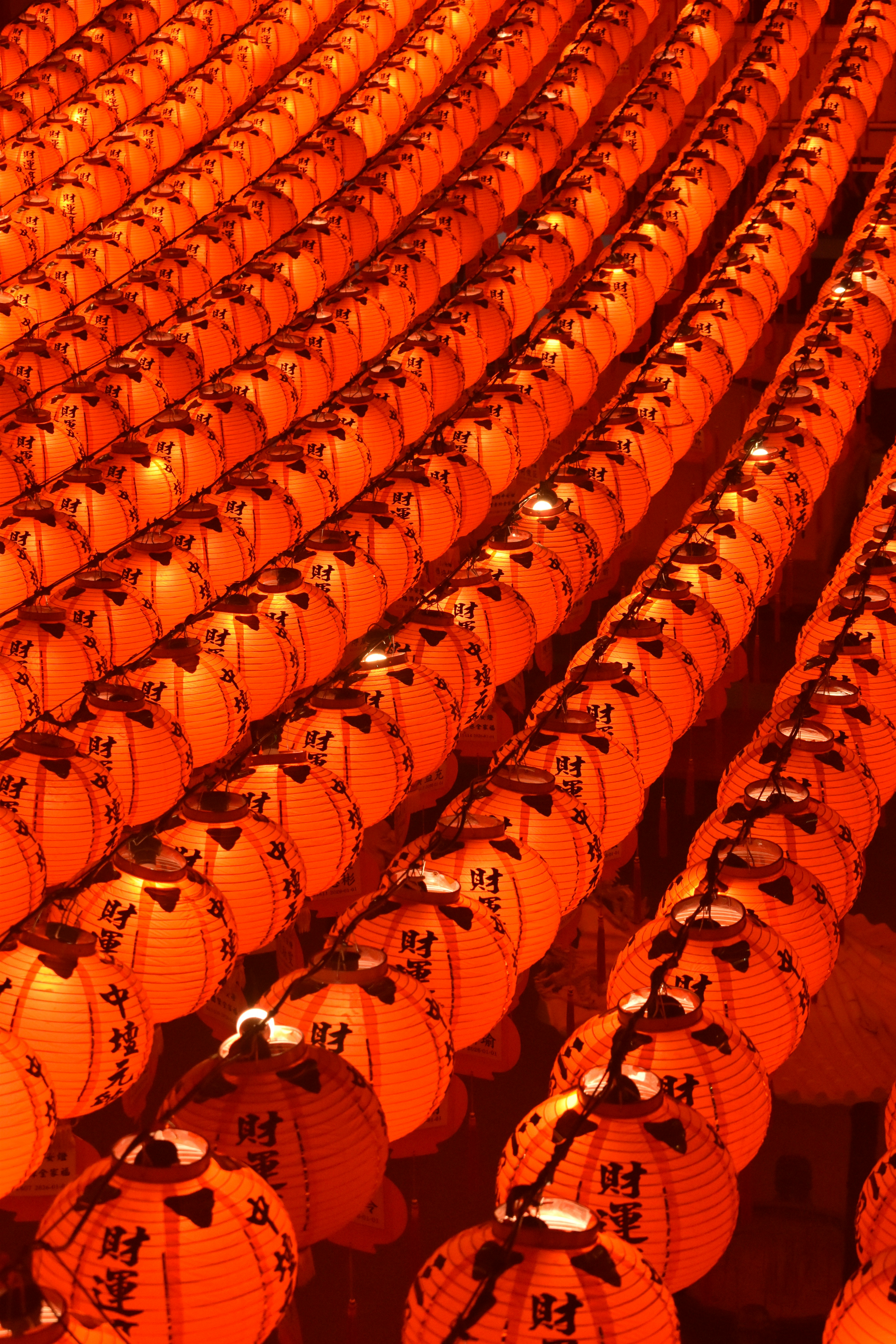 Rows of bright orange lanterns hanging in a pattern