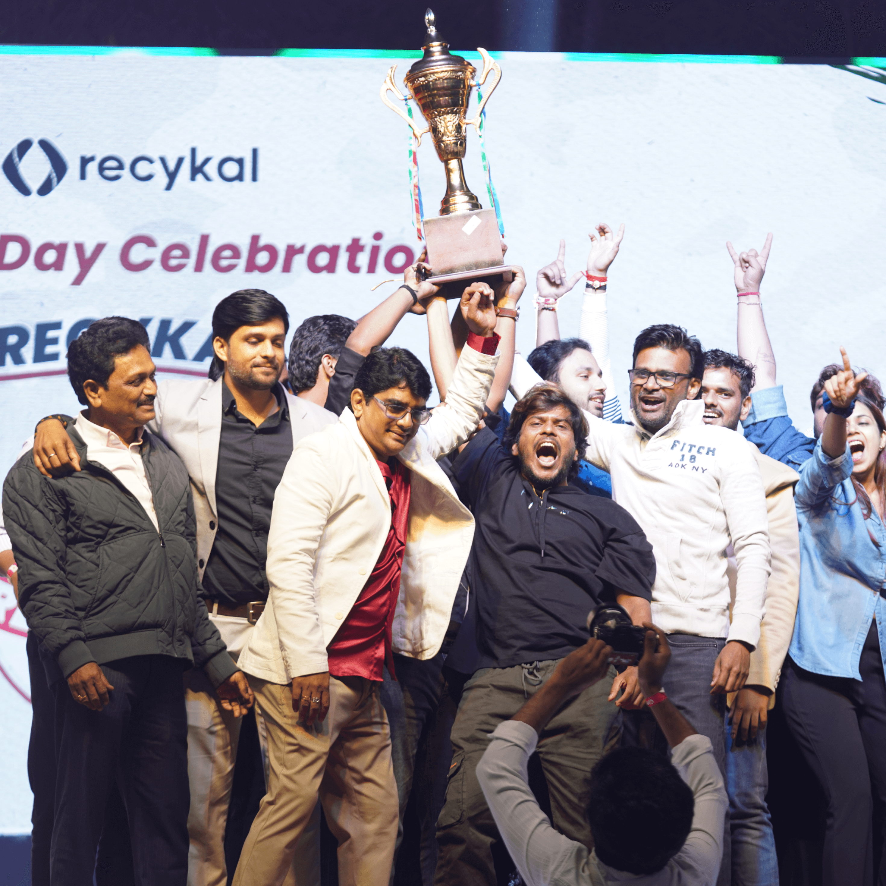 Woman in red outfit poses by a red telephone booth.