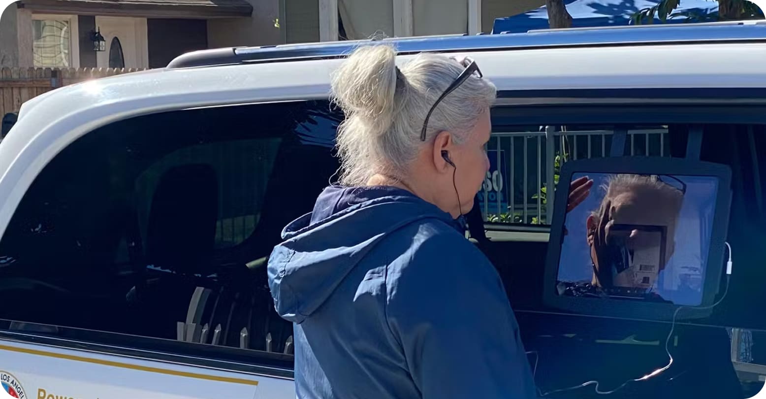 A woman looking at a laptop that is positioned in a van