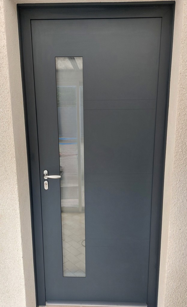 Porte d’entrée moderne grise avec une fente vitrée verticale et poignée métallique.