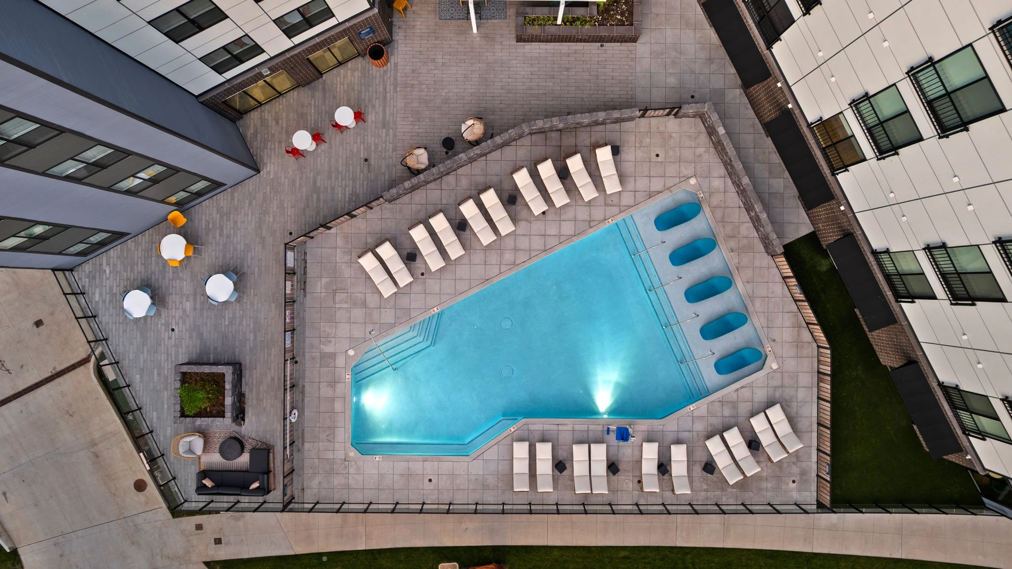 Aerial view of a swimming pool surrounded by lounge chairs, showcasing a relaxing outdoor space.