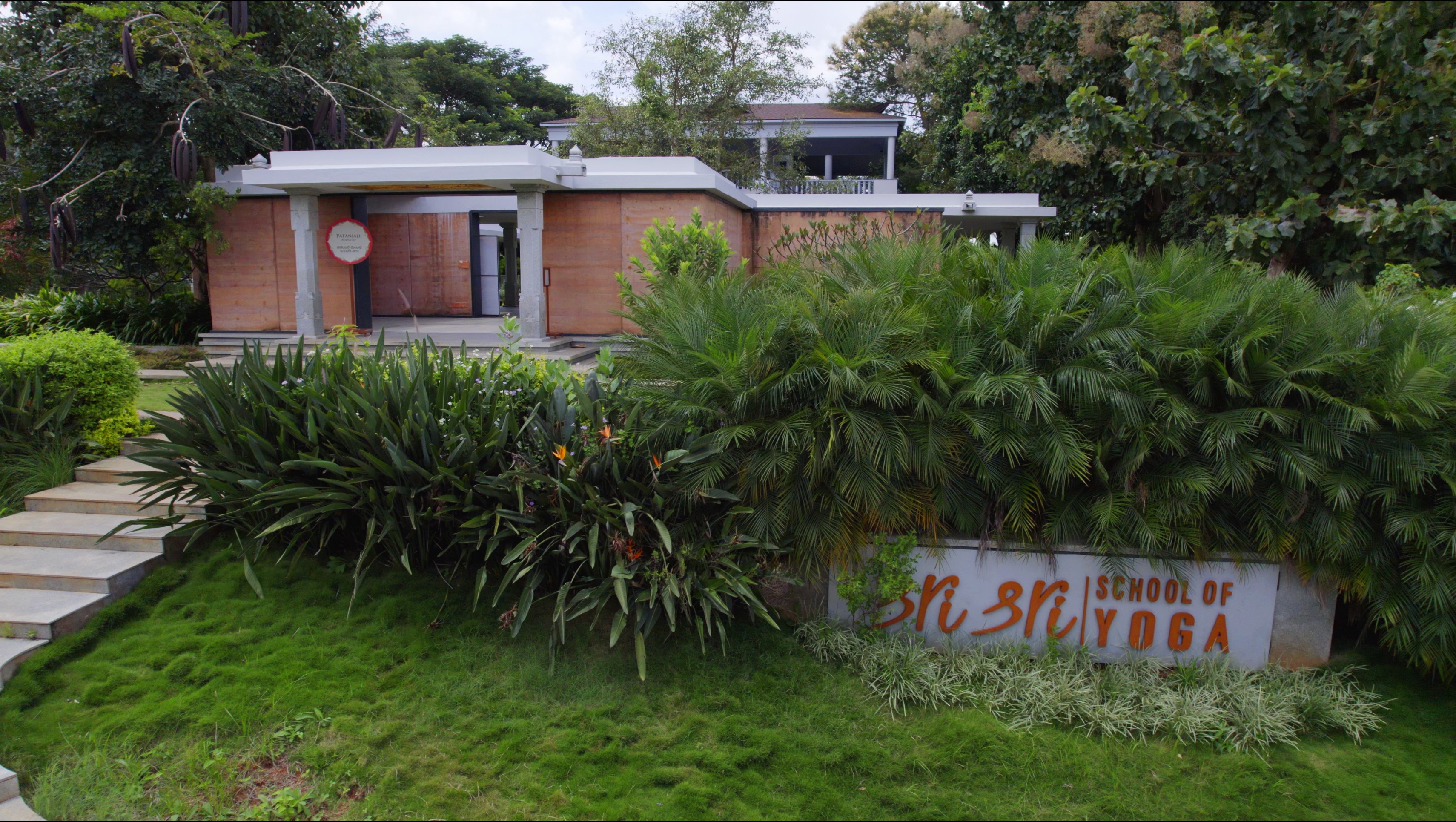 Aerial view of a winding road cutting through rocky terrain and sandy landscape.