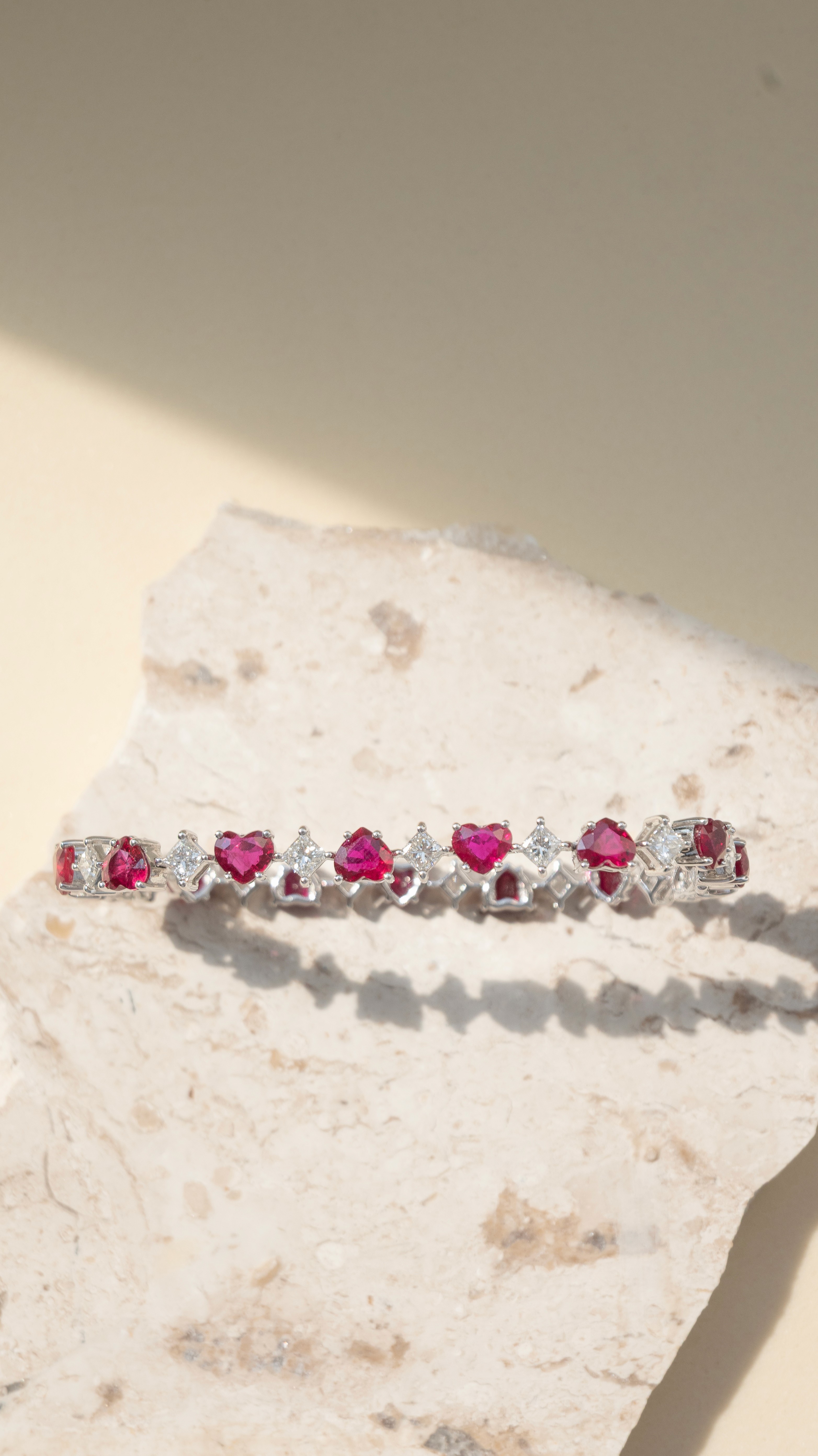 S-Curve Ruby earrings in 18k white gold, pear-shaped Mozambique rubies falling through a diamond-set curve