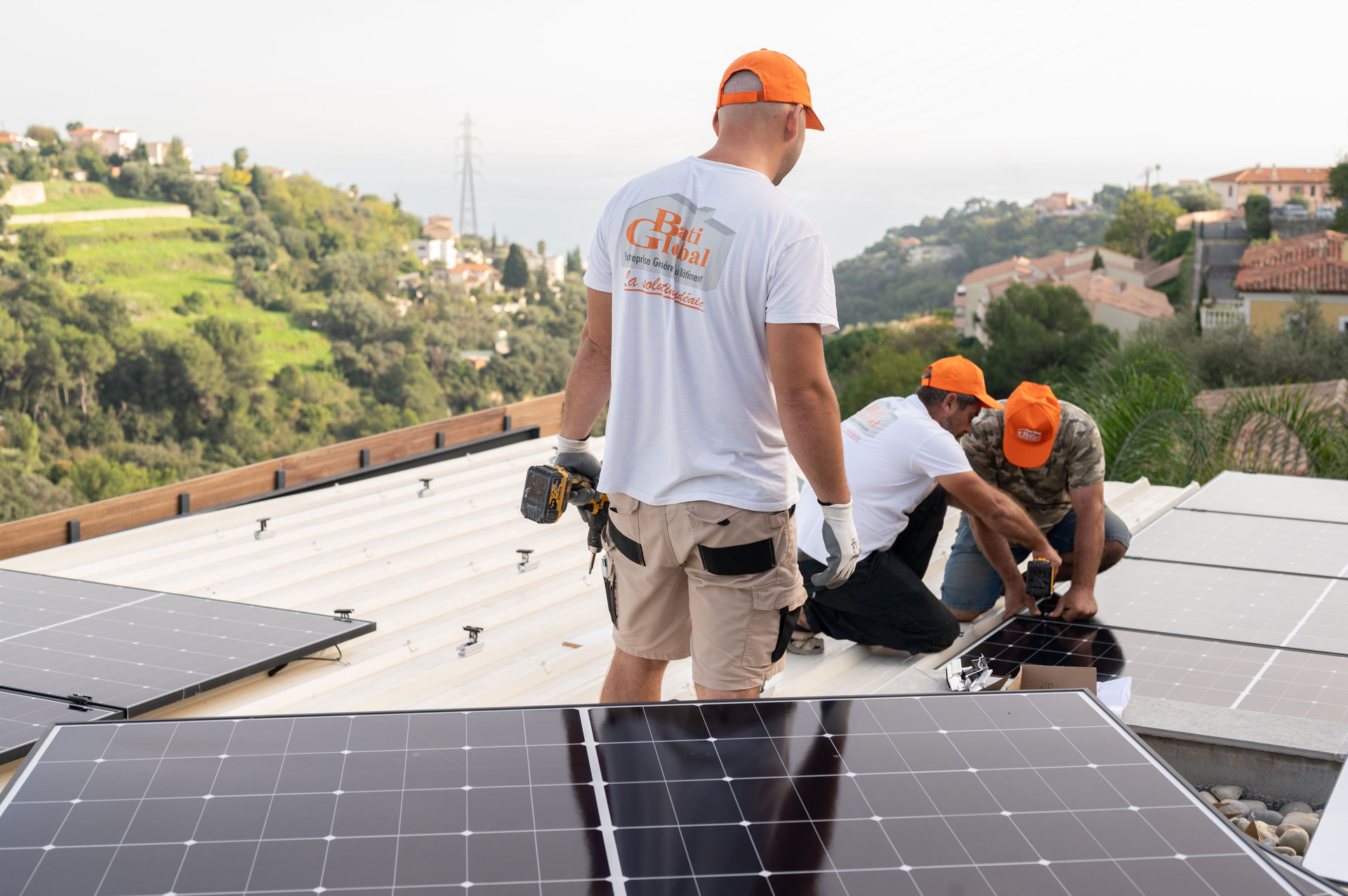 Ouvriers Batiglobal entrain de poser des panneaux photovoltaïques sur un toit