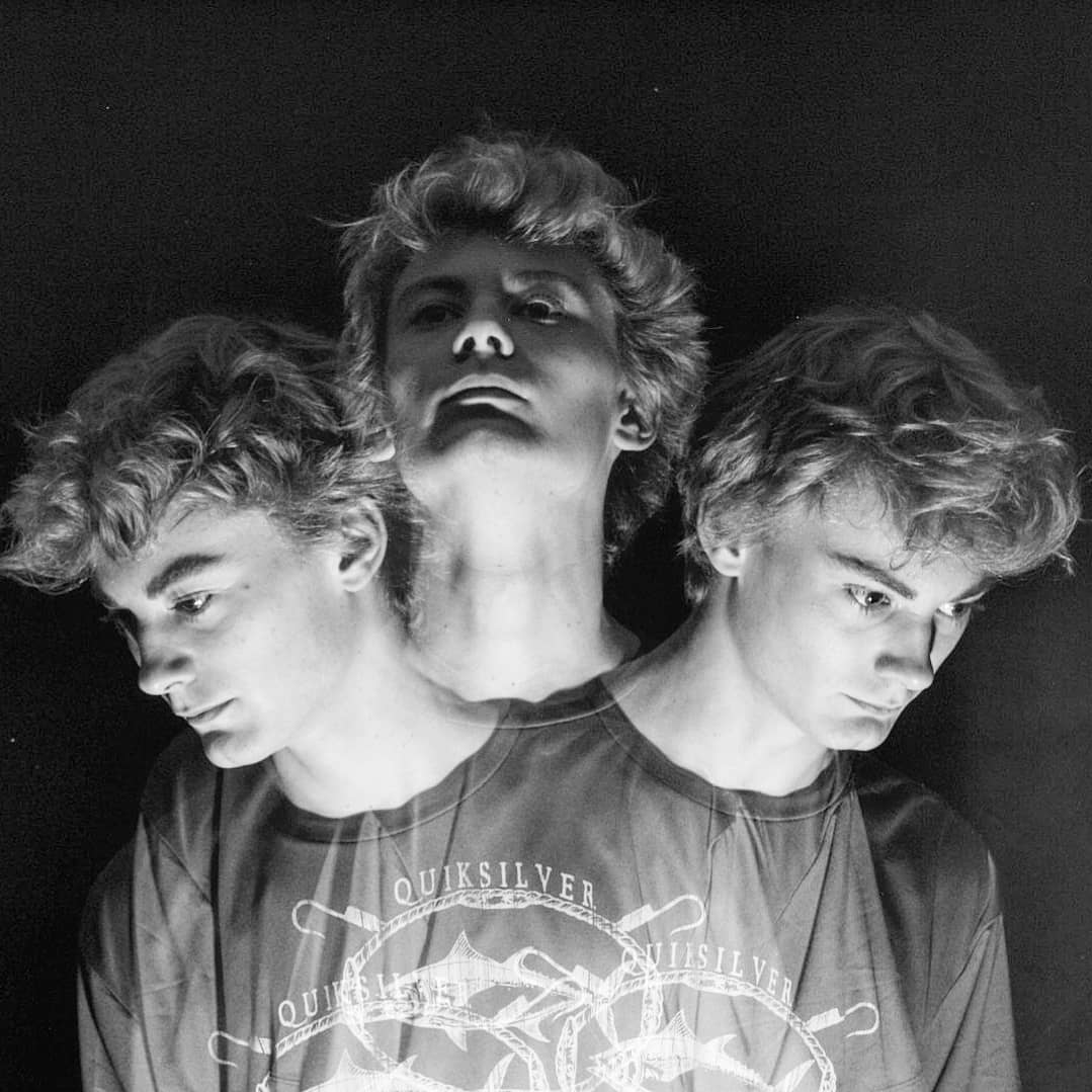 Portrait of man looking to the left and smiling with a dark background