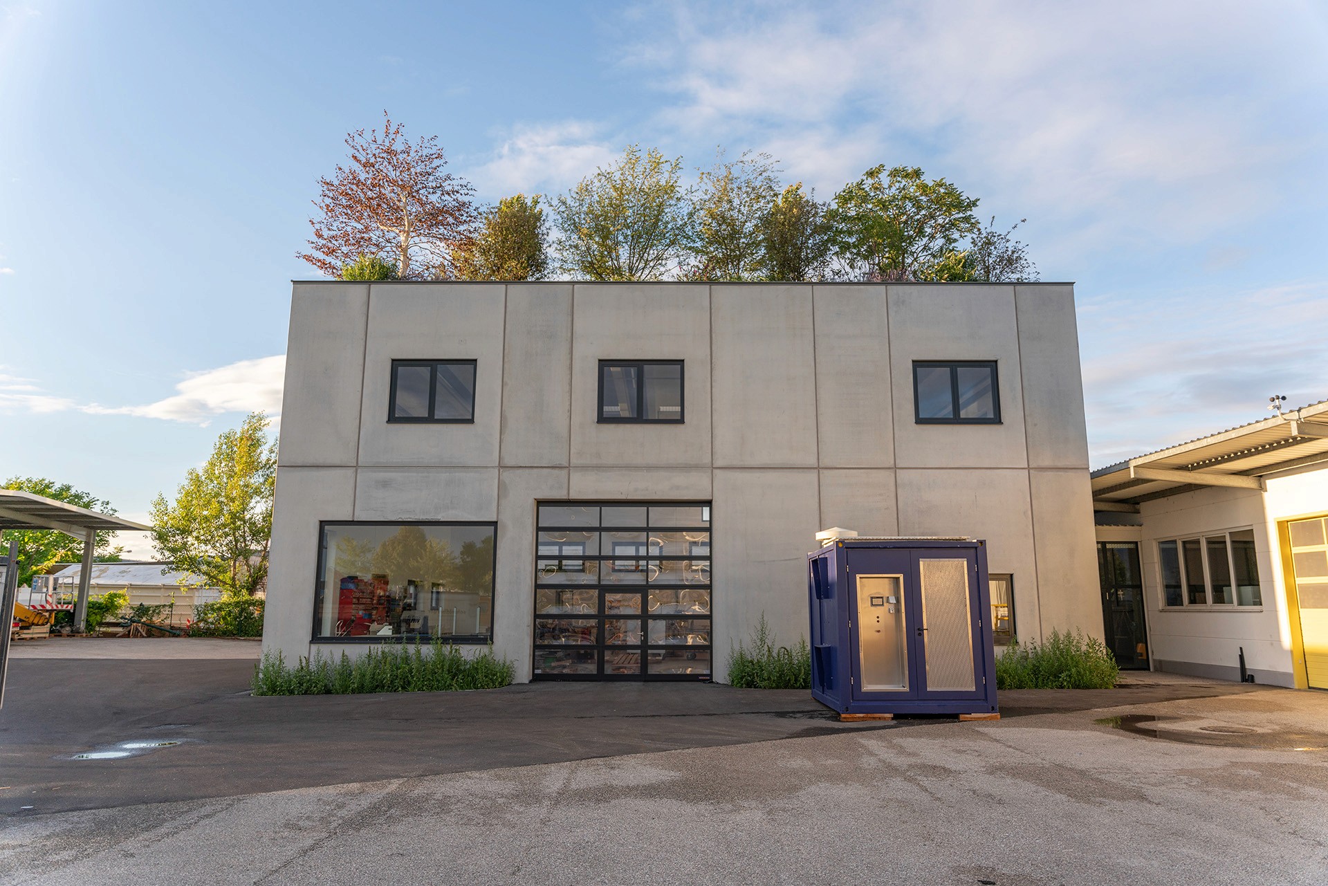 Gebäude mit bepflanztem Dachgarten, auf dem Sträucher und Bäume wachsen.