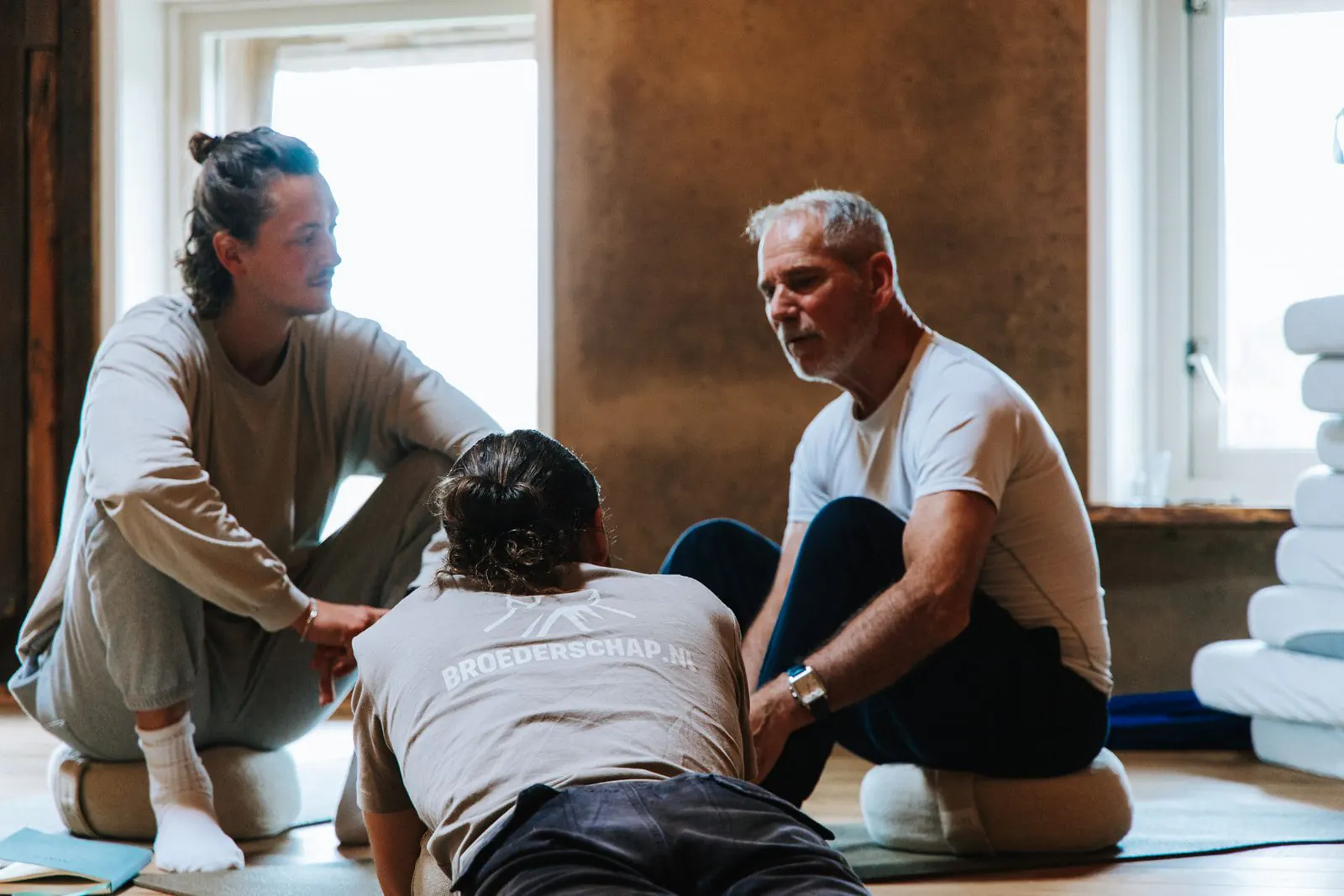 Mannen lachen samen tijdens een speelse oefening op het mannenweekend