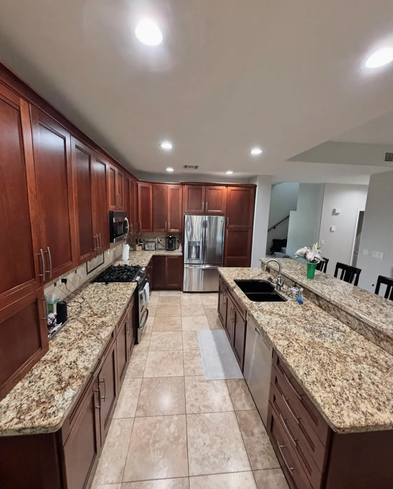 Professionally cleaned kitchen with polished granite countertops, sanitized stainless steel appliances, and dust-free cherry wood cabinetry.