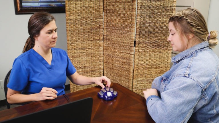 Practitioner performing Zyto Biofeedback Scan using hand cradle device