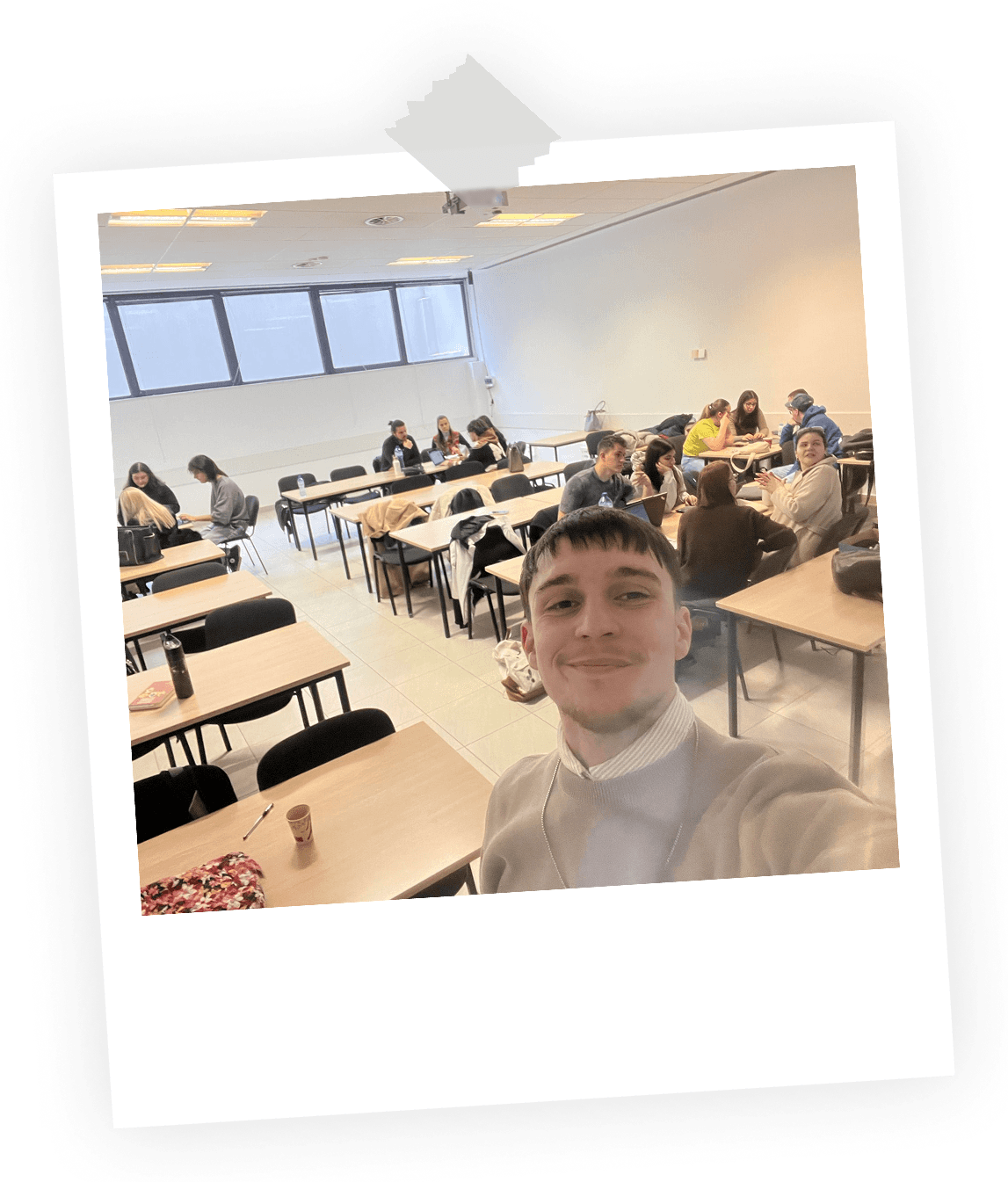 A selfie of Phil with working design student in the back of a classroom