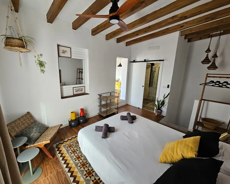 Gemütliches Schlafzimmer mit freiliegenden Holzbalken und natürlichem Licht in La Terraza Tarifa