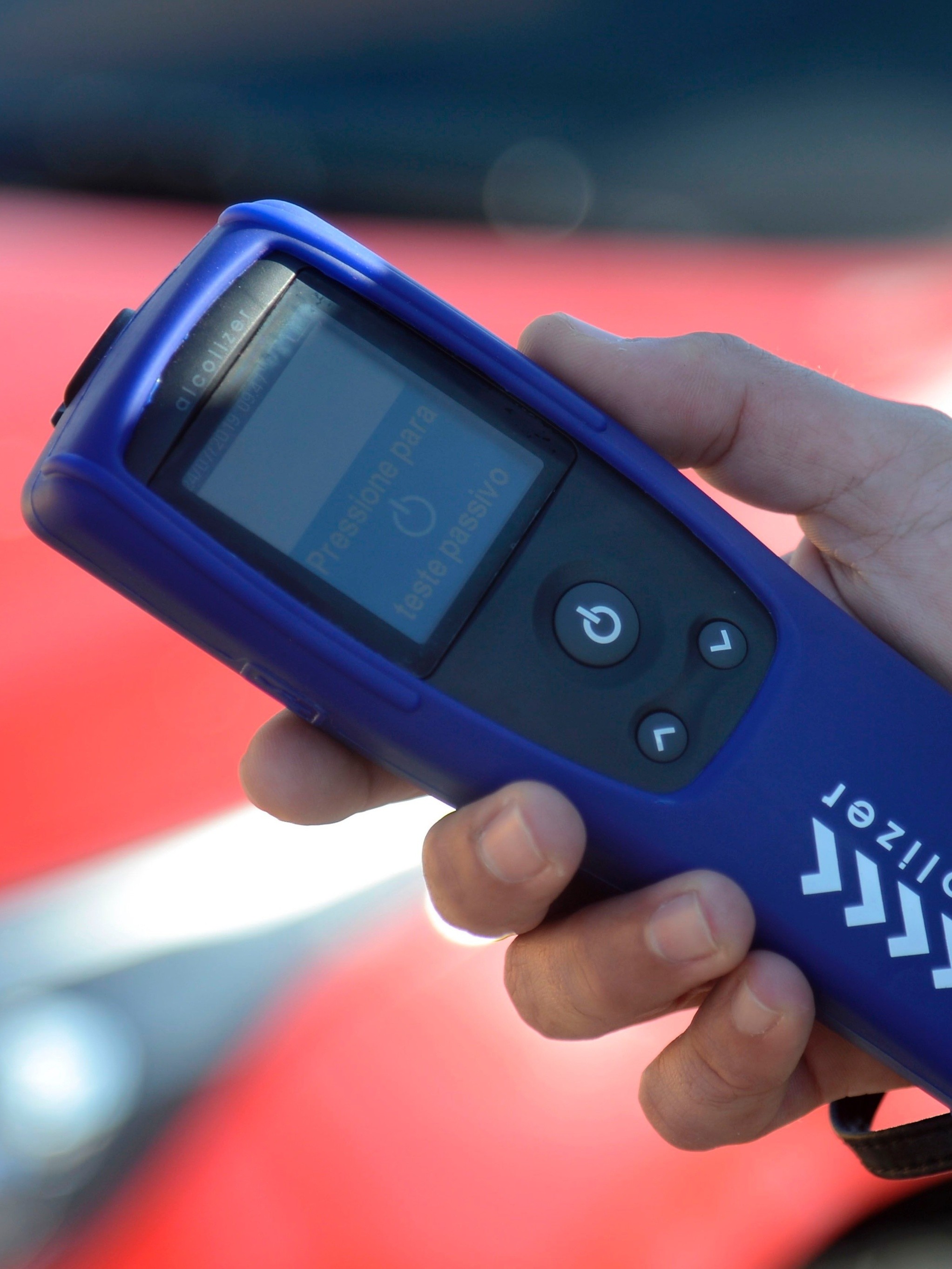Profissional vestindo capacete e colete fluorescente apoiado em corrimão ambiente industrial.