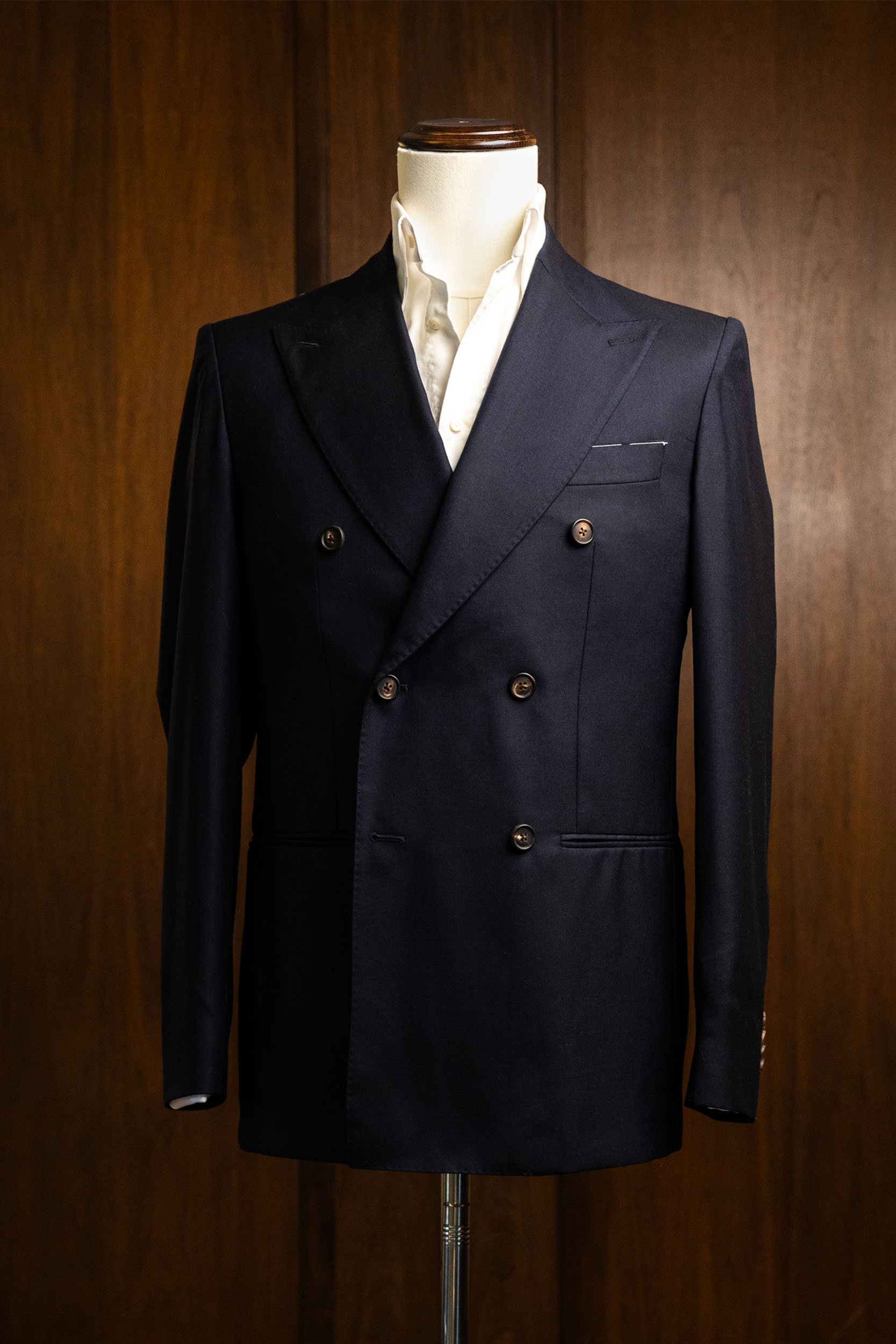 A refined navy double-breasted Don Marrón jacket on a mannequin, featuring sharp peak lapels, clean structure, and elevated menswear craftsmanship.